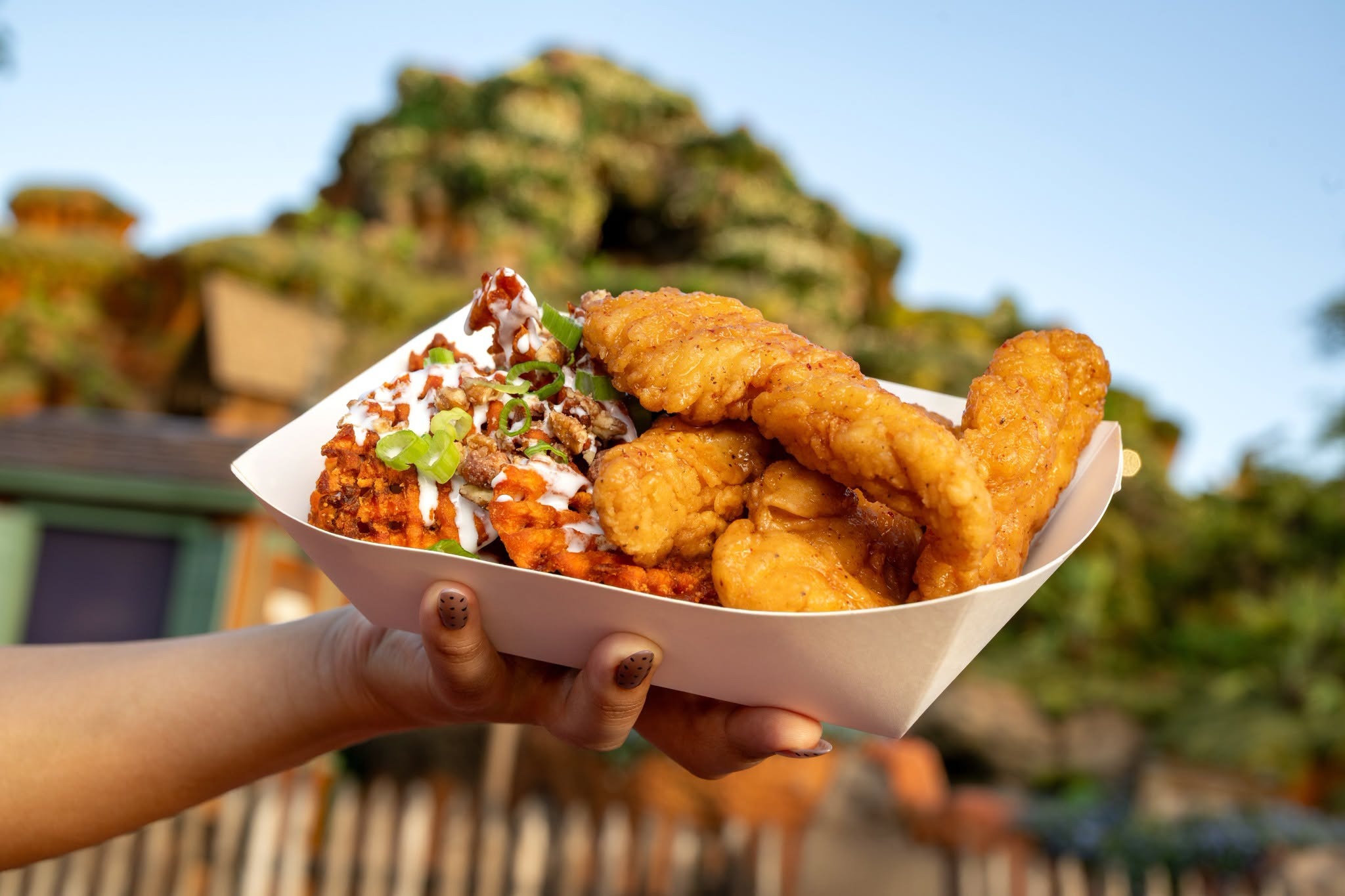 At the Golden Oak Outpost kiosk, guests can order the Hot Honey Chicken Strips with marshmallow and candied pecan-topped sweet potato waffle fries.