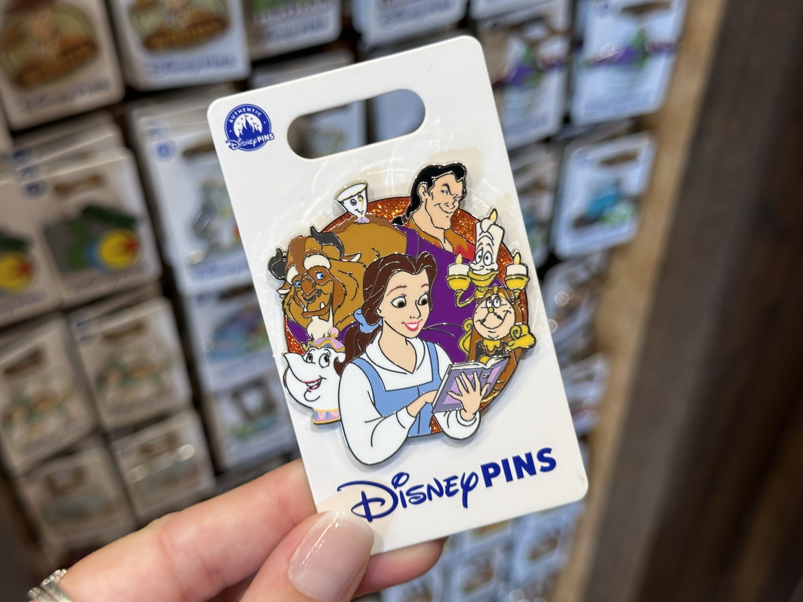 This cast pin features several characters from Beauty and the Beast: Belle, Lumiere, Cogsworth, Mrs. Potts, Gaston, Beast, and Chip.