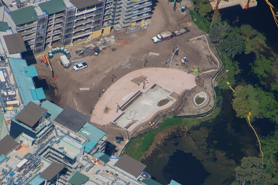 There appear to be light poles in place around the pool deck, which was paved last month, though we cannot be sure from photos if they are temporary lights or permanent ones.