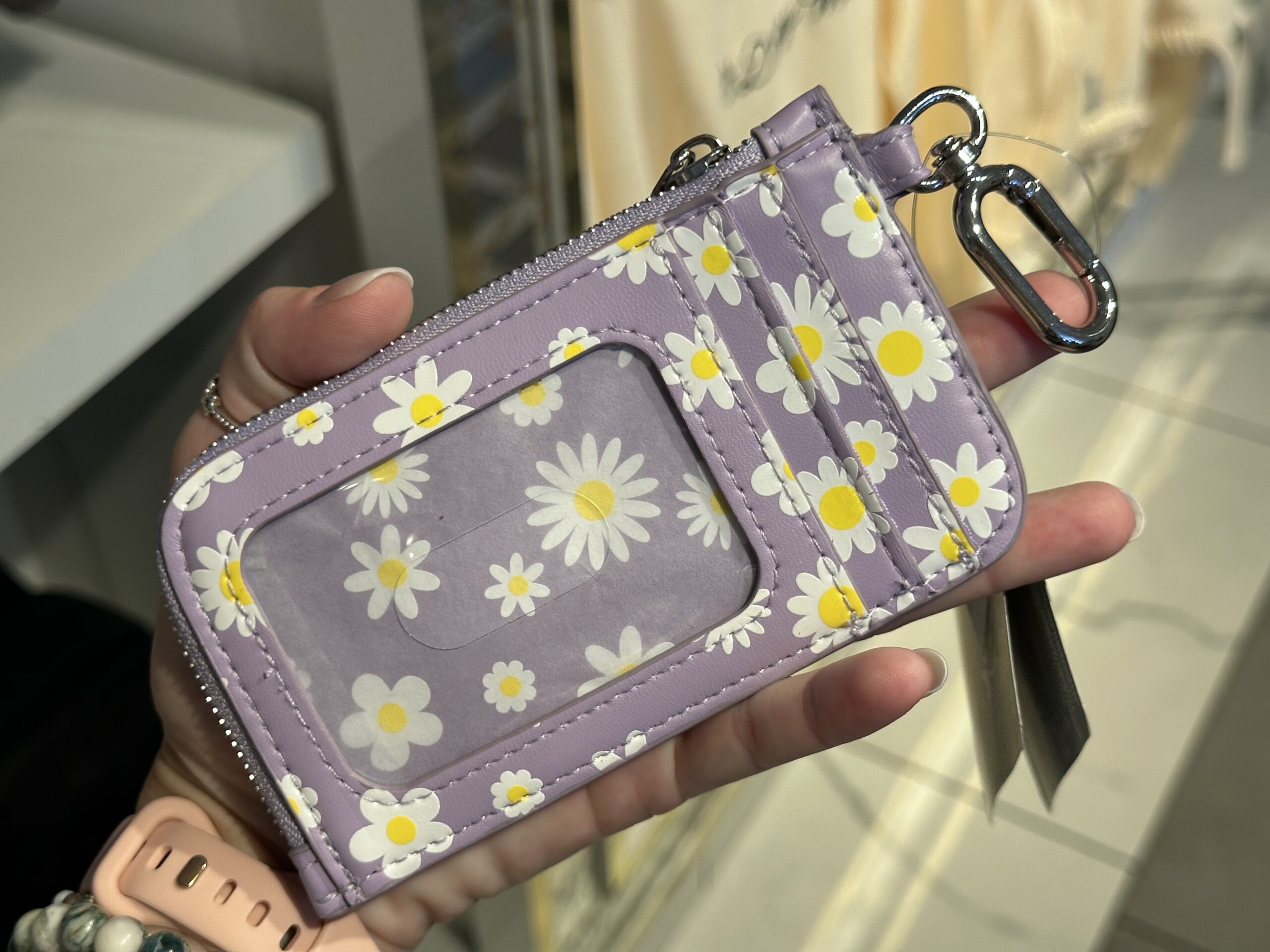In lavender, this keychain wallet has colorful daisy flowers on it as well as Daisy Duck herself. The back of the wallet just has the repeating daisy flower pattern as well as two card slots and an ID card section.