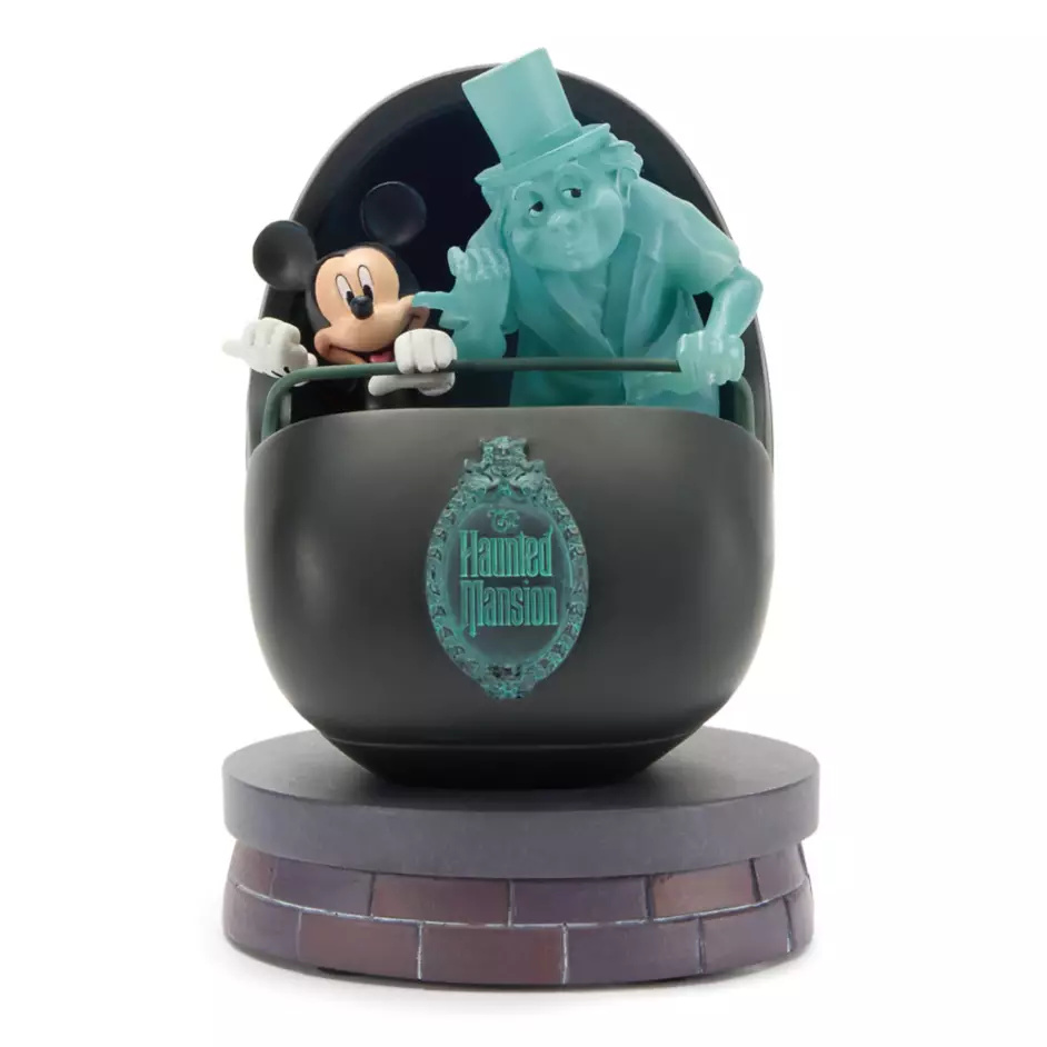 Mickey Mouse is depicted in a Doom Buggy alongside Phineas the Hitchhiking Ghost. The sculpted resin figure is 5.5" tall. Phineas is translucent blue and lights up from within. The Haunted Mansion plaque is on the front of the buggy and it sits on a faux brick base.