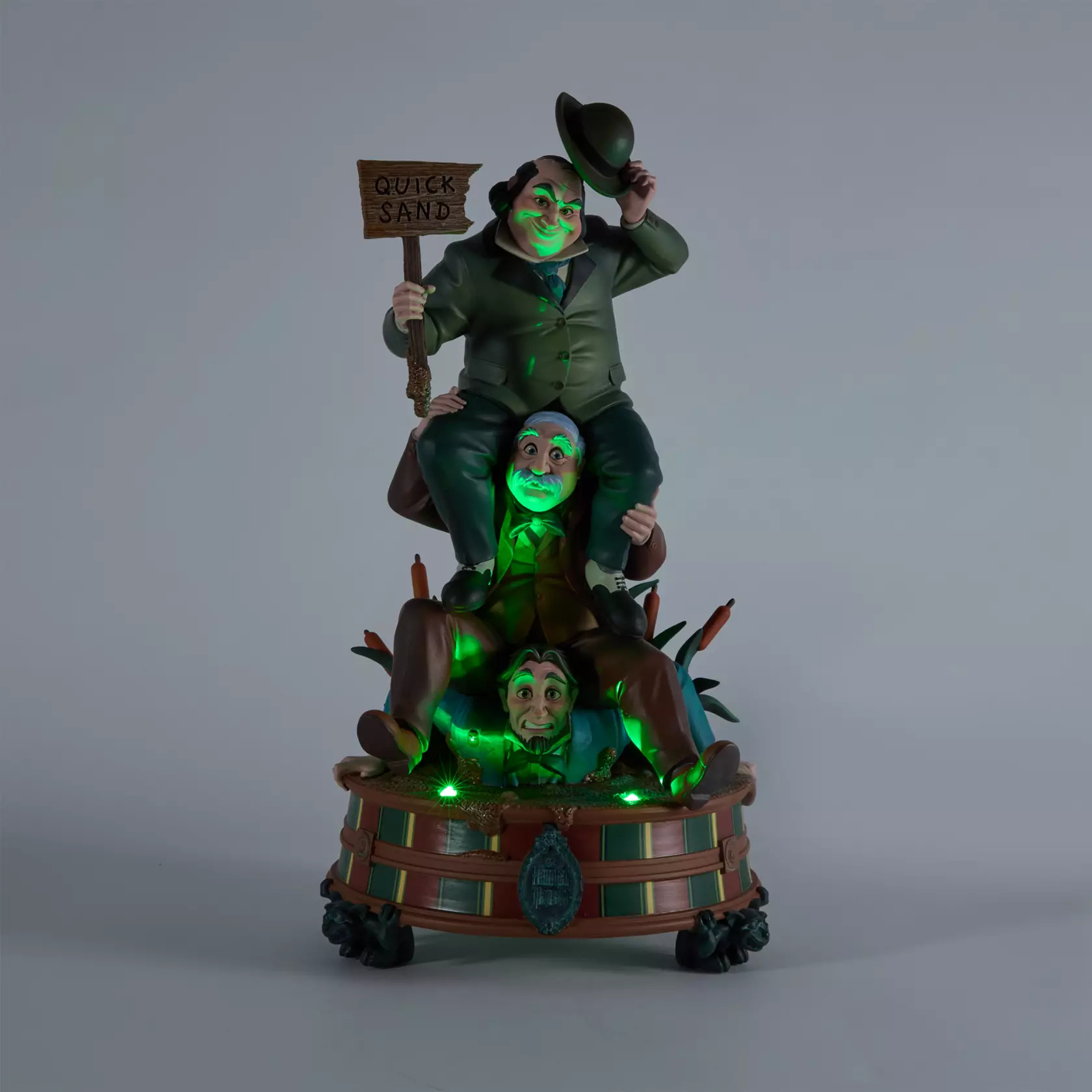 This 13 3/4" sculpted figure, also designed by Steven Thompson, depicts another Stretching Room portrait. Three gentlemen sit on each other's shoulders as they descend into quick sand. It also has multicolored lights shining up from the base.