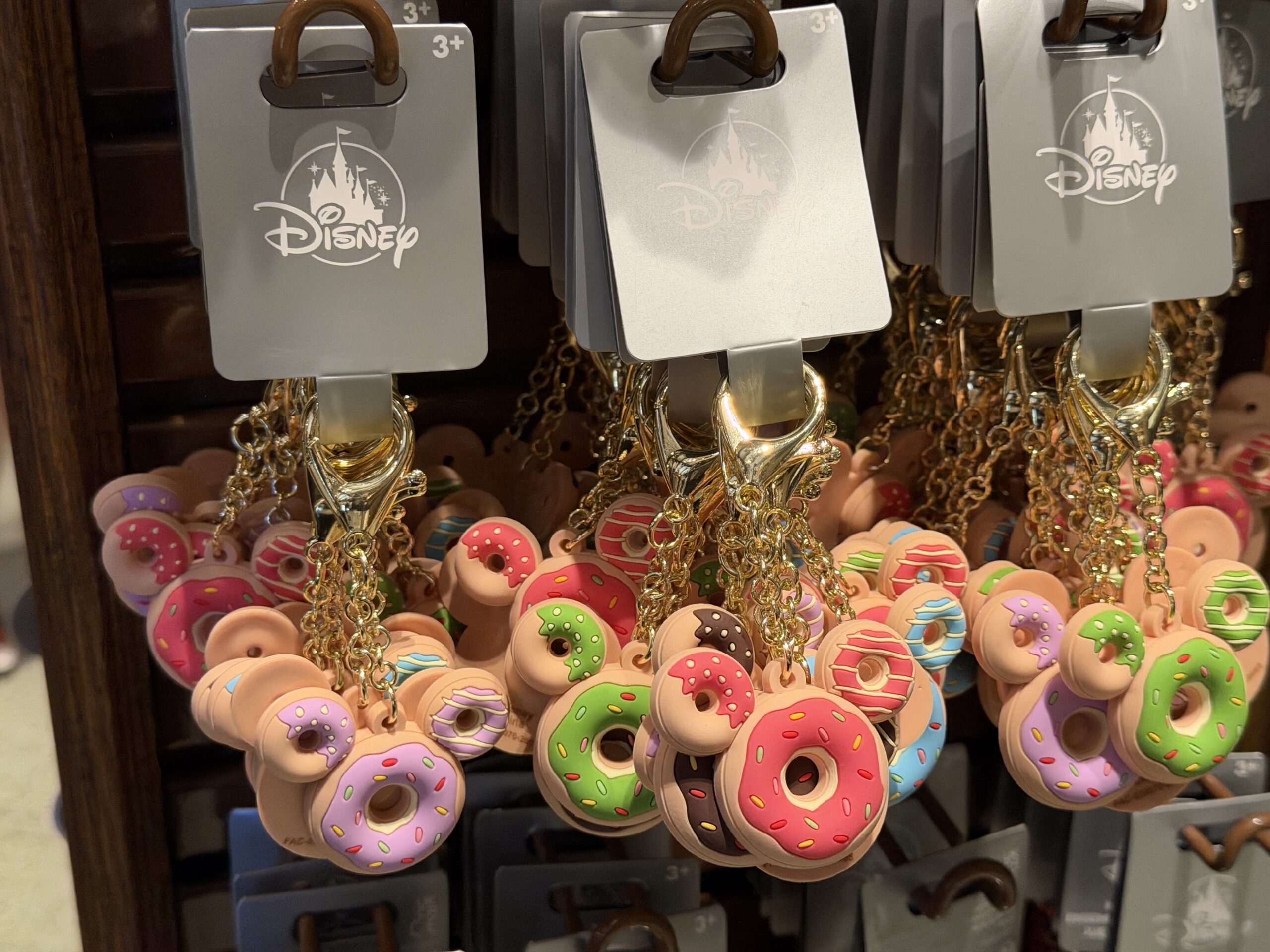 And share these keychains with four of your closest friends. Each one is a Mickey-shaped donut with different colored frosting: blue, purple, chocolate brown, green, and pink.