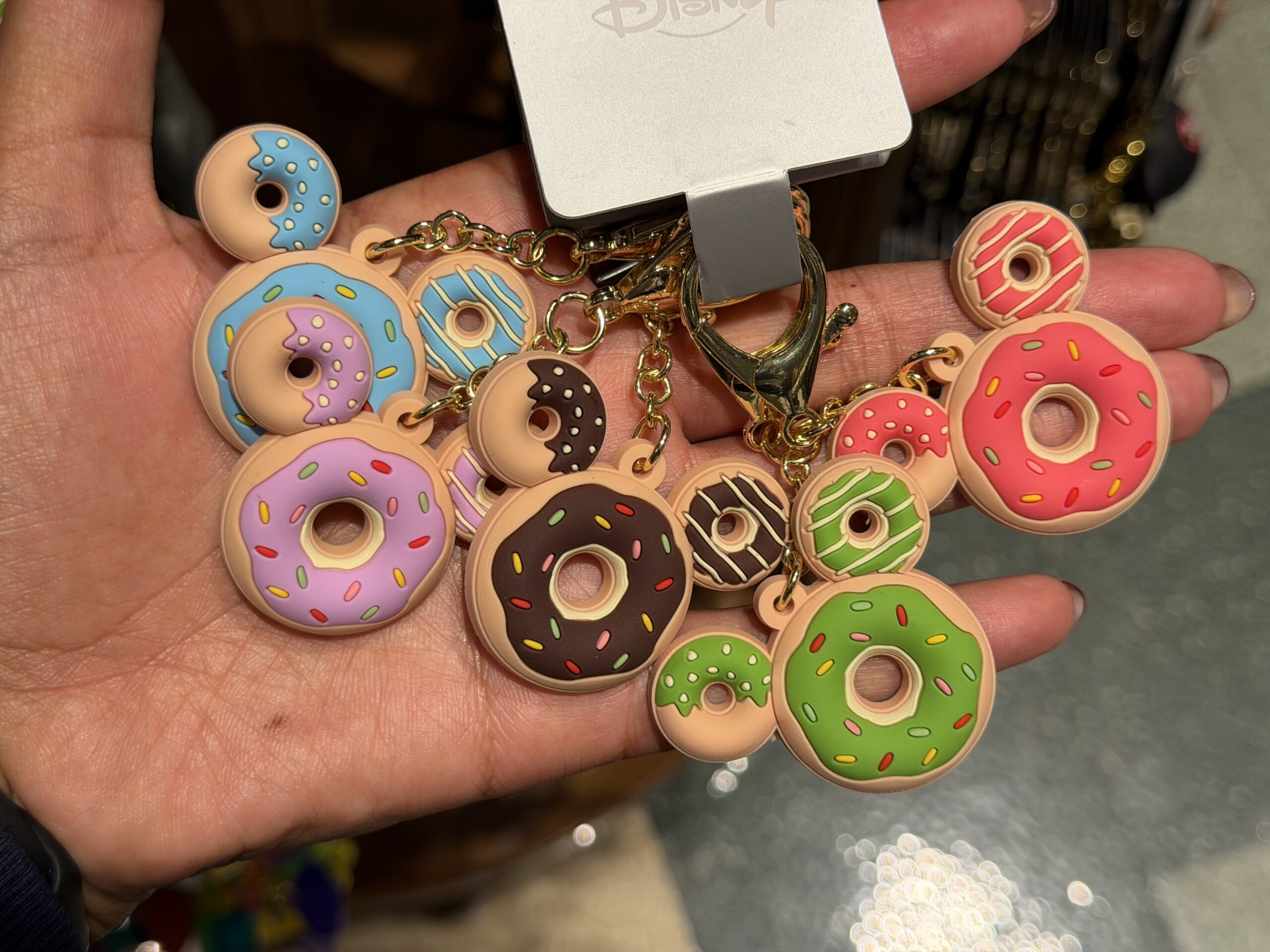 And share these keychains with four of your closest friends. Each one is a Mickey-shaped donut with different colored frosting: blue, purple, chocolate brown, green, and pink.
