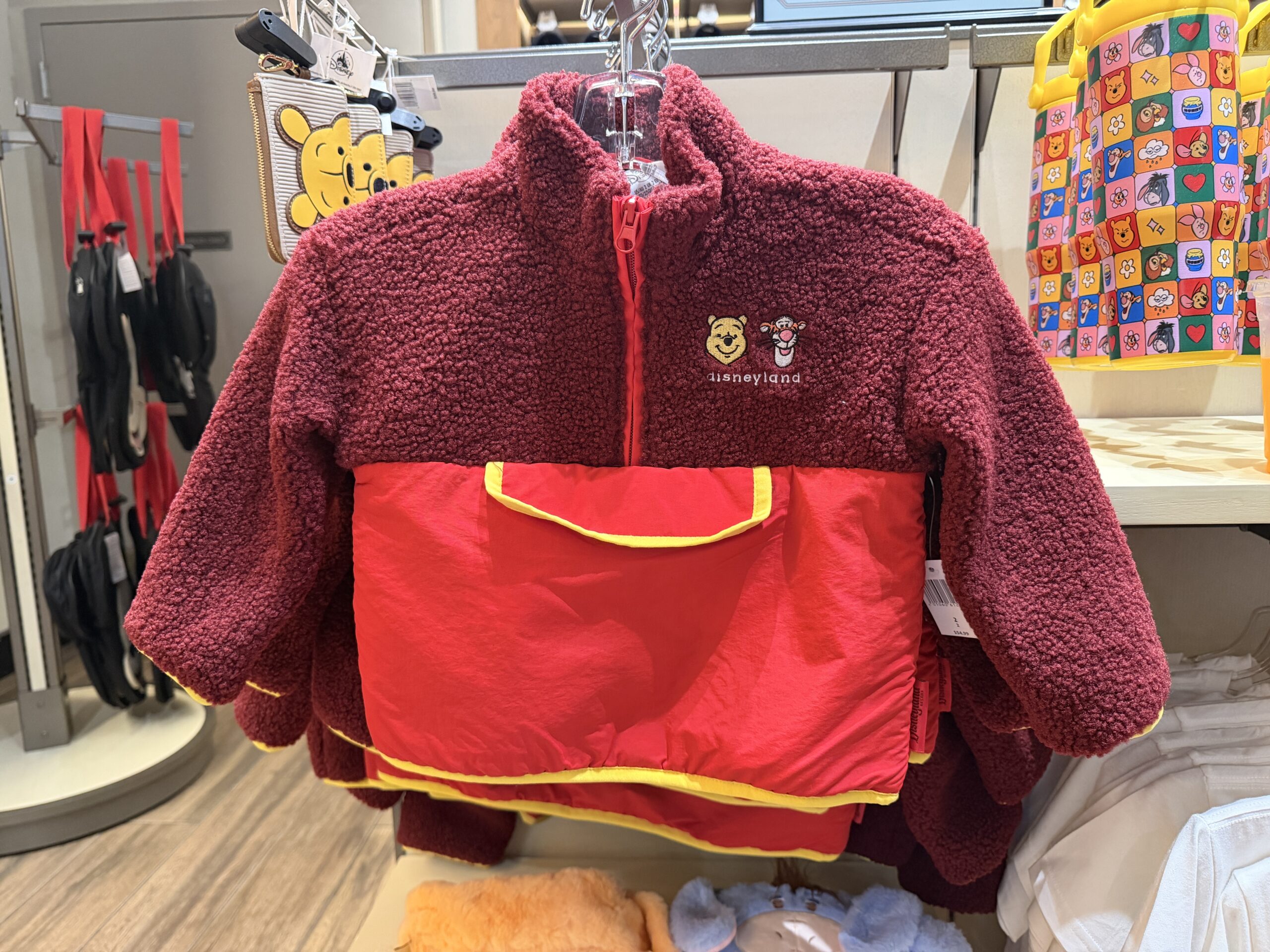This half-zip jacket has a red fleece top half with a cadet collar. The bottom half is brighter red with yellow trim.
