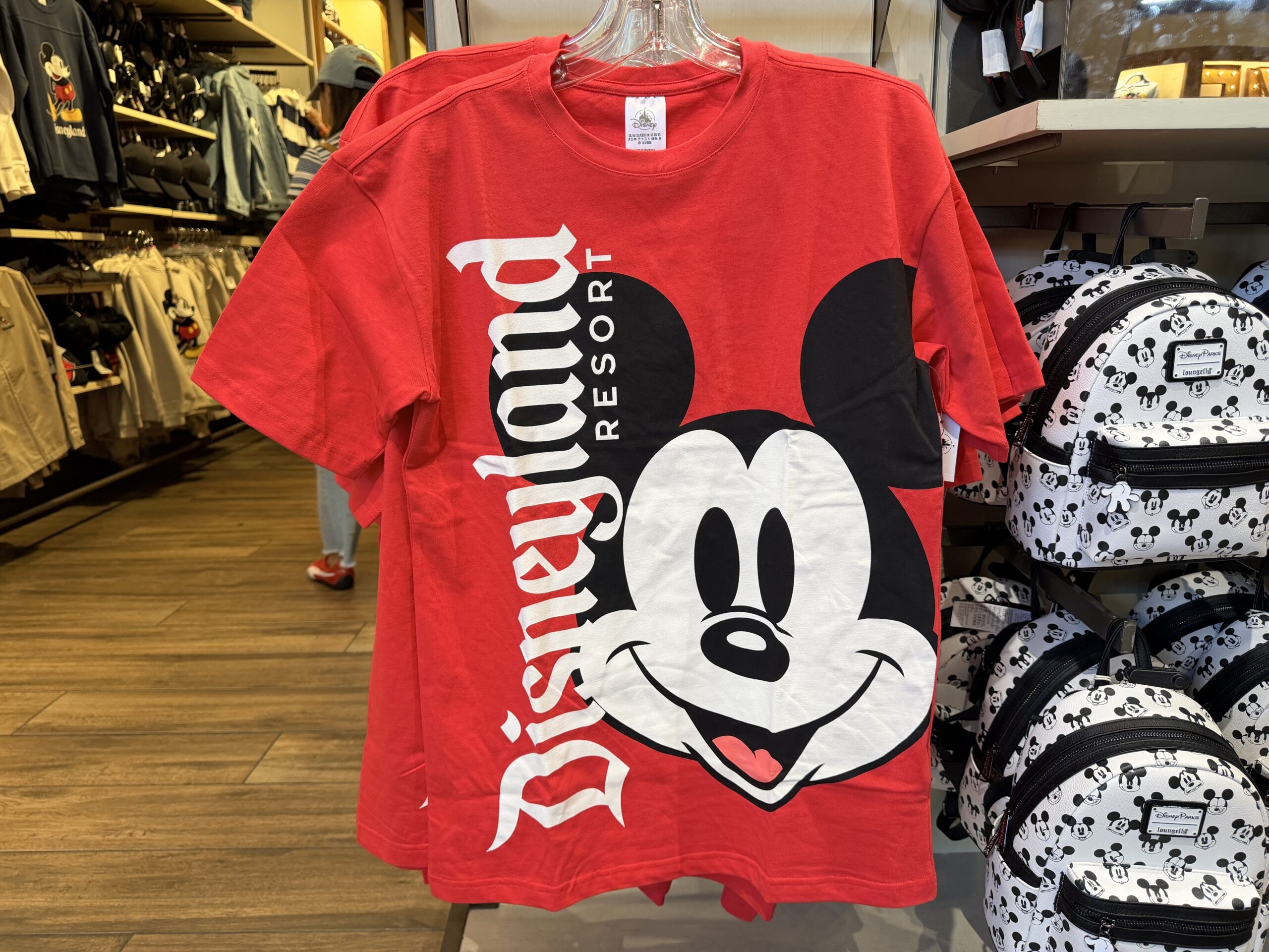 Mickey's face is in black and white on this red short-sleeved tee. "Disneyland Resort" is down the right side of the chest in white, crossing over Mickey's ear.