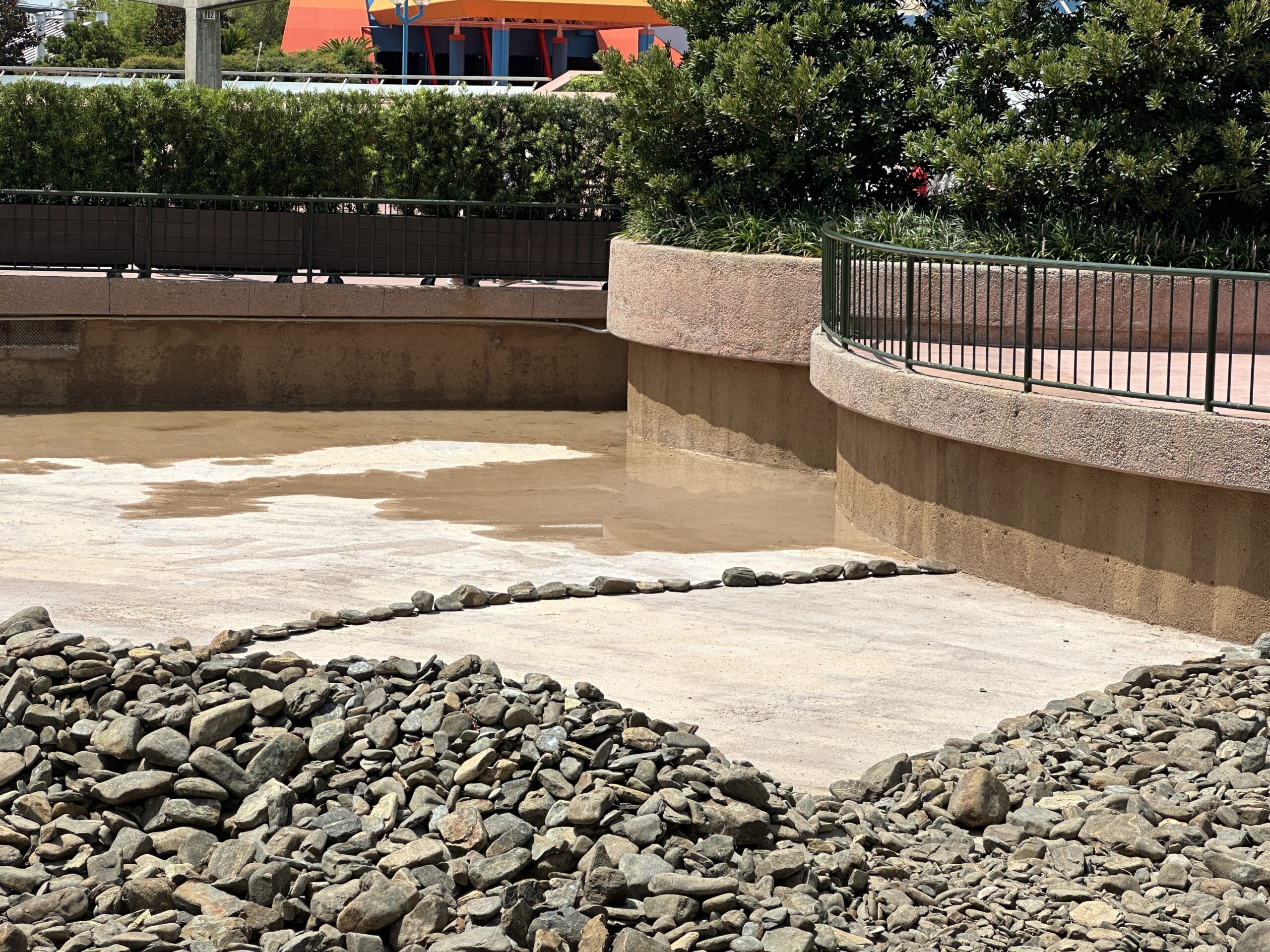 The rocks have been filled in where the bottom of the reflecting pool was recently repainted. There is a line of rocks along the bottom of the pool (as seen in the lefthand photo above) which we presume indicates an area that may need to be repainted. All coins that were mixed in with the rocks have also been removed.