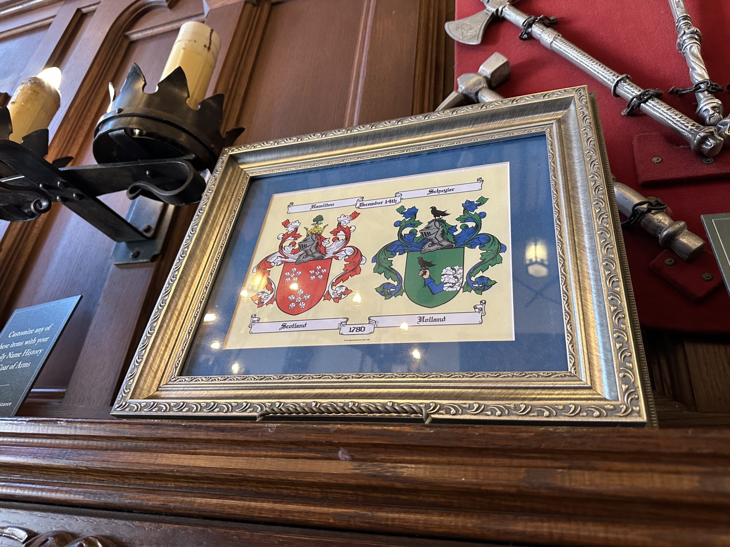 The Hamilton and Schuyler family crests are displayed together, referencing Alexander Hamilton and Elizabeth Schuyler's union on December 14, 1780. Hamilton's crest is from Scotland, and Schuyler's is from Holland. Hamilton was a Founding Father as well as the first U.S. Secretary of the Treasury and a founder of the Federalist Party. He is also the central focus of the award-winning musical of the same name.