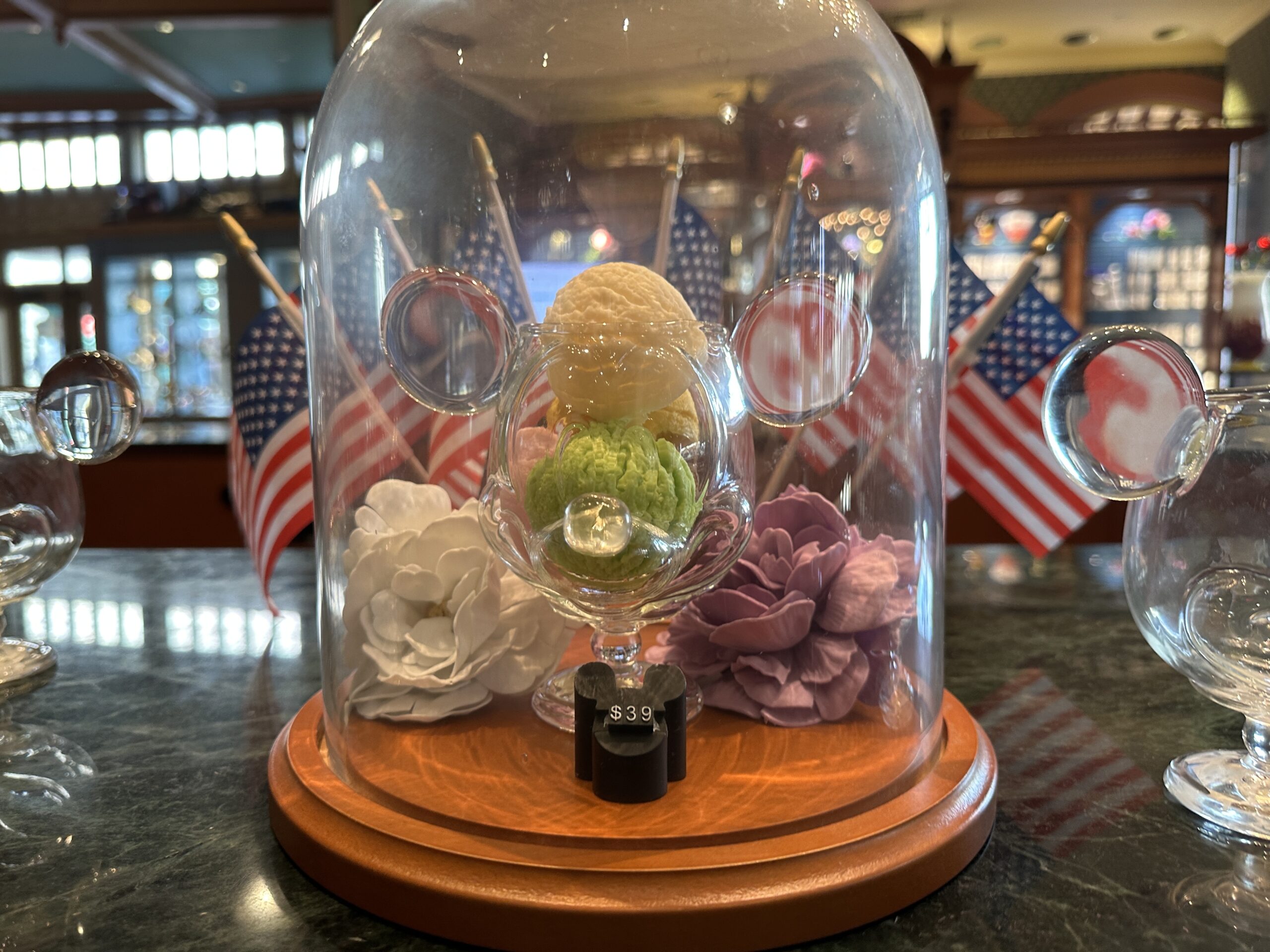 Crystal Arts is displaying one of the Mickey dishes with scoops of ice cream in it under a cloche at their Main Street, U.S.A. location.