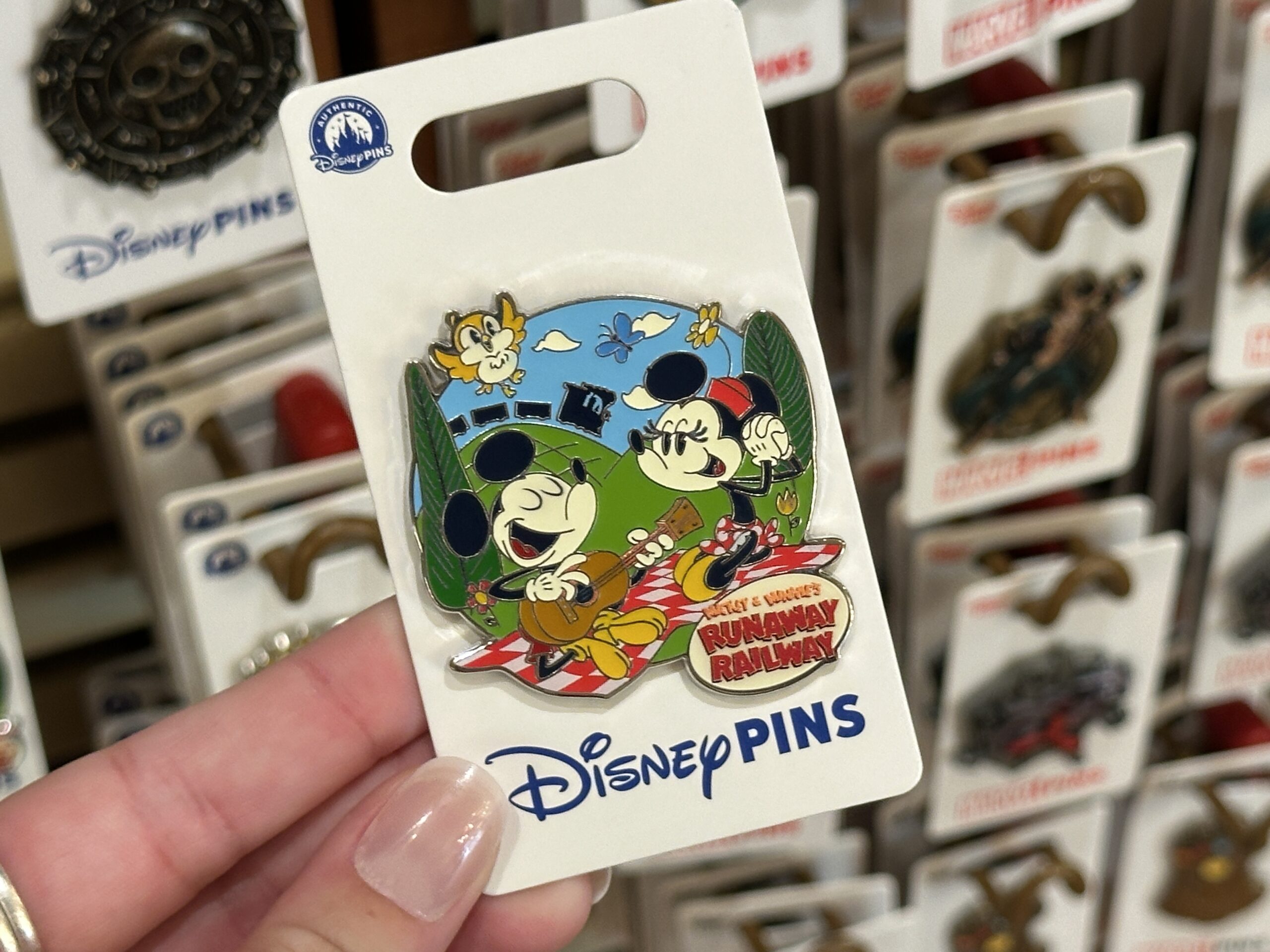Mickey & Minnie's Runaway Railway finale is represented on this pin, with Mickey and Minnie on a picnic blanket while a train moves over the distant hills. The Mickey & Minnie’s Runaway Railway logo is in the lower corner. Chuuby is above.