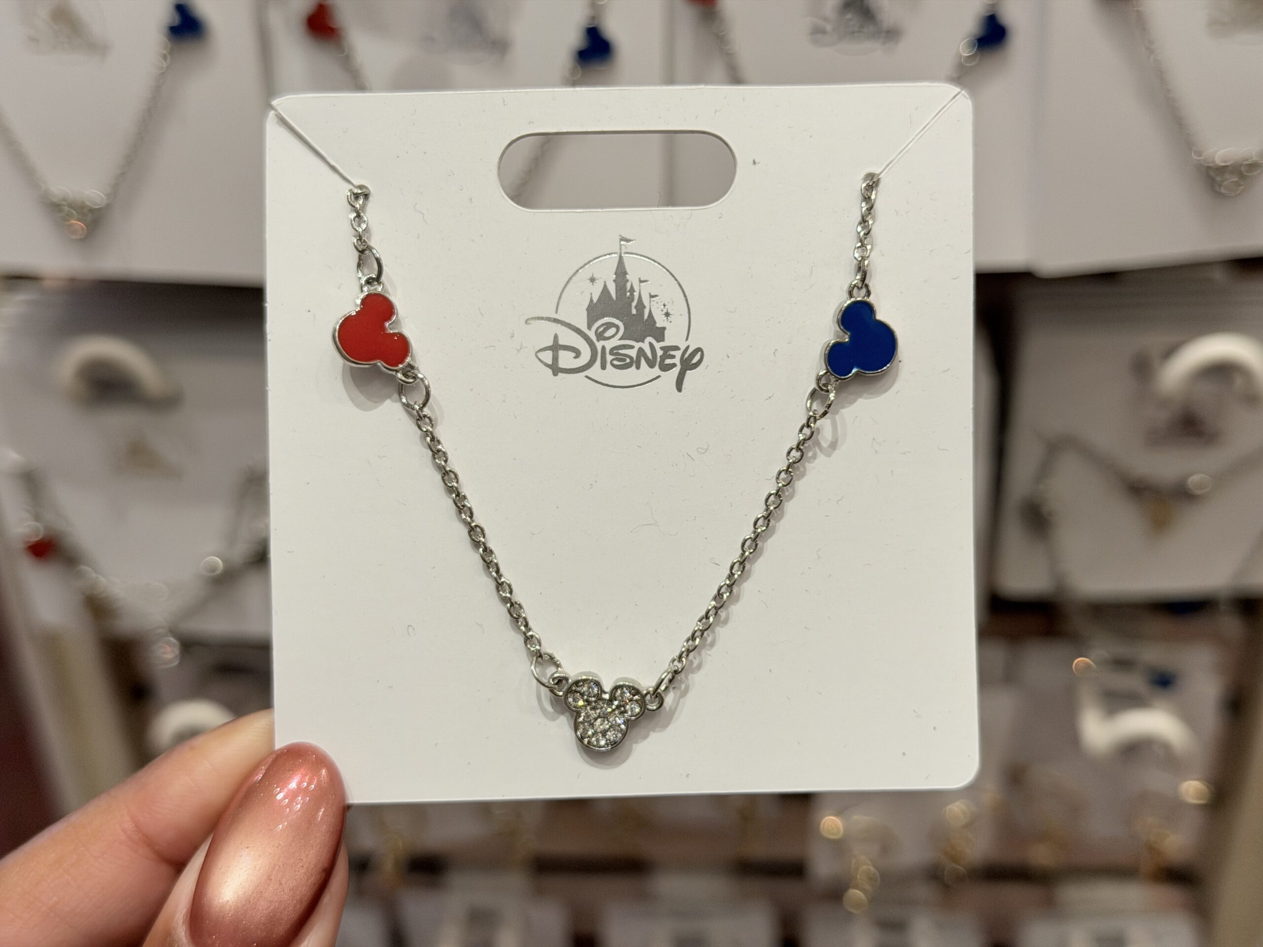 This necklace features red, white, and blue Mickey head icons. There are rhinestones inside the "white" icon at the center.