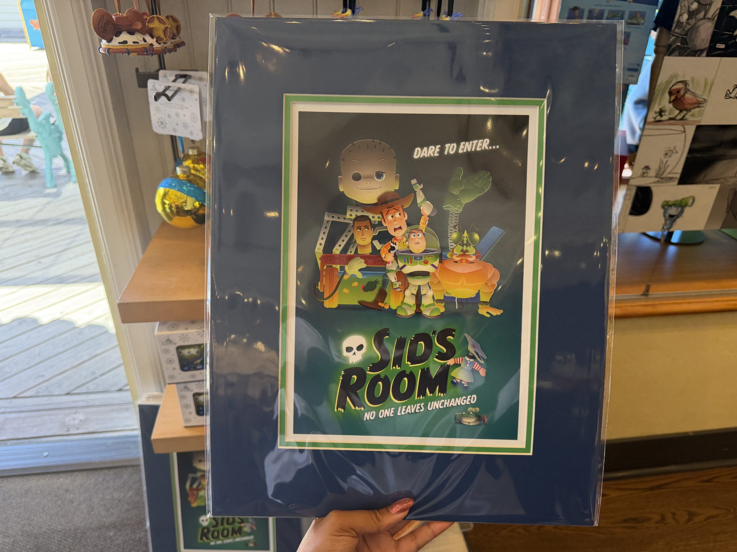 Similar to the art above, this is also in Maruyama's style. It features characters from Sid's room like Babyface and Janie along with Buzz Lightyear and Woody. At the top reads "Dare to enter..." and at the bottom says "Sid's Room no one leaves unchanged."