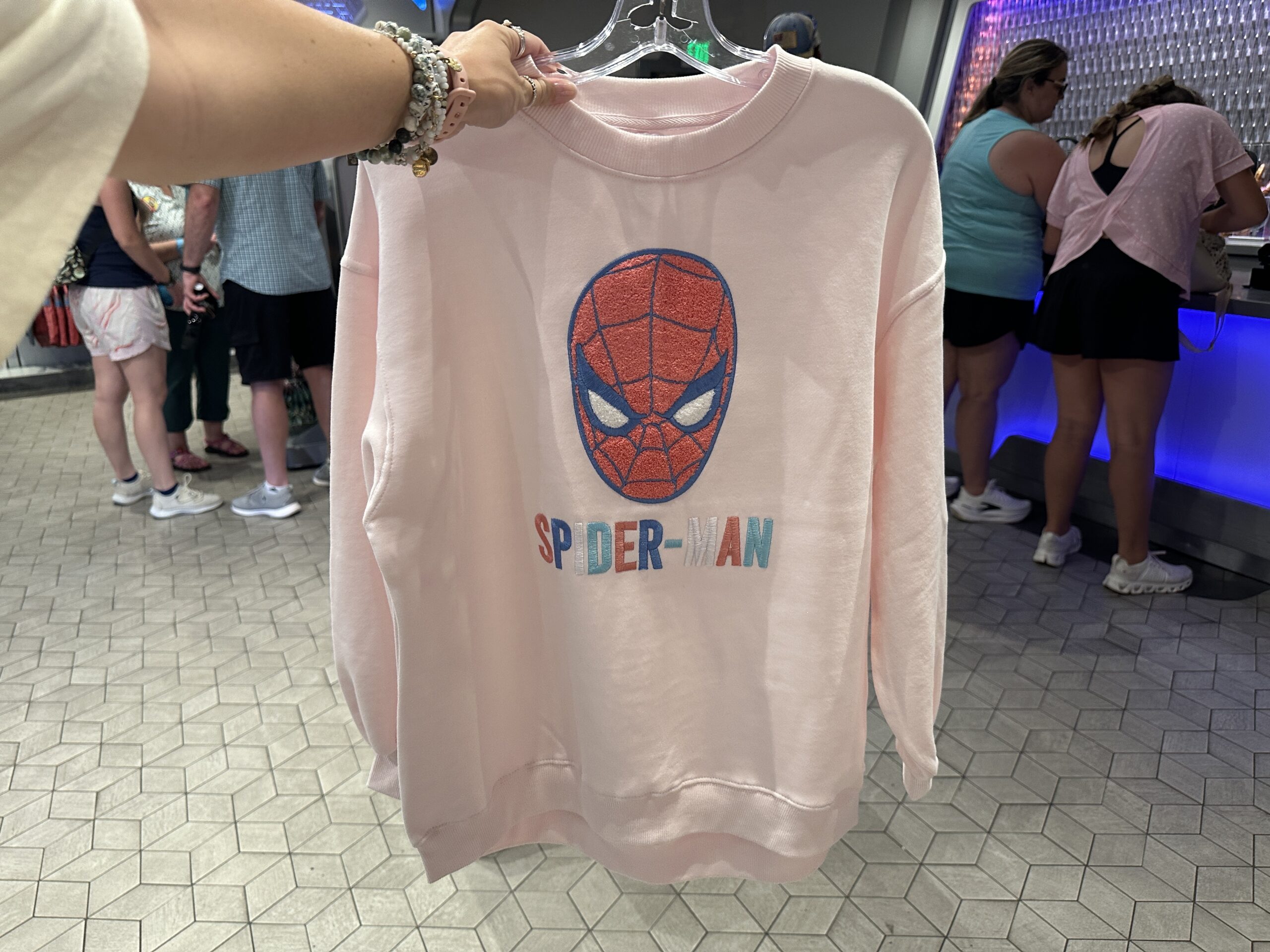 This light pink pullover has a chenille patch of Spider-Man's masked face above his name in multicolored patches. The back is plain.