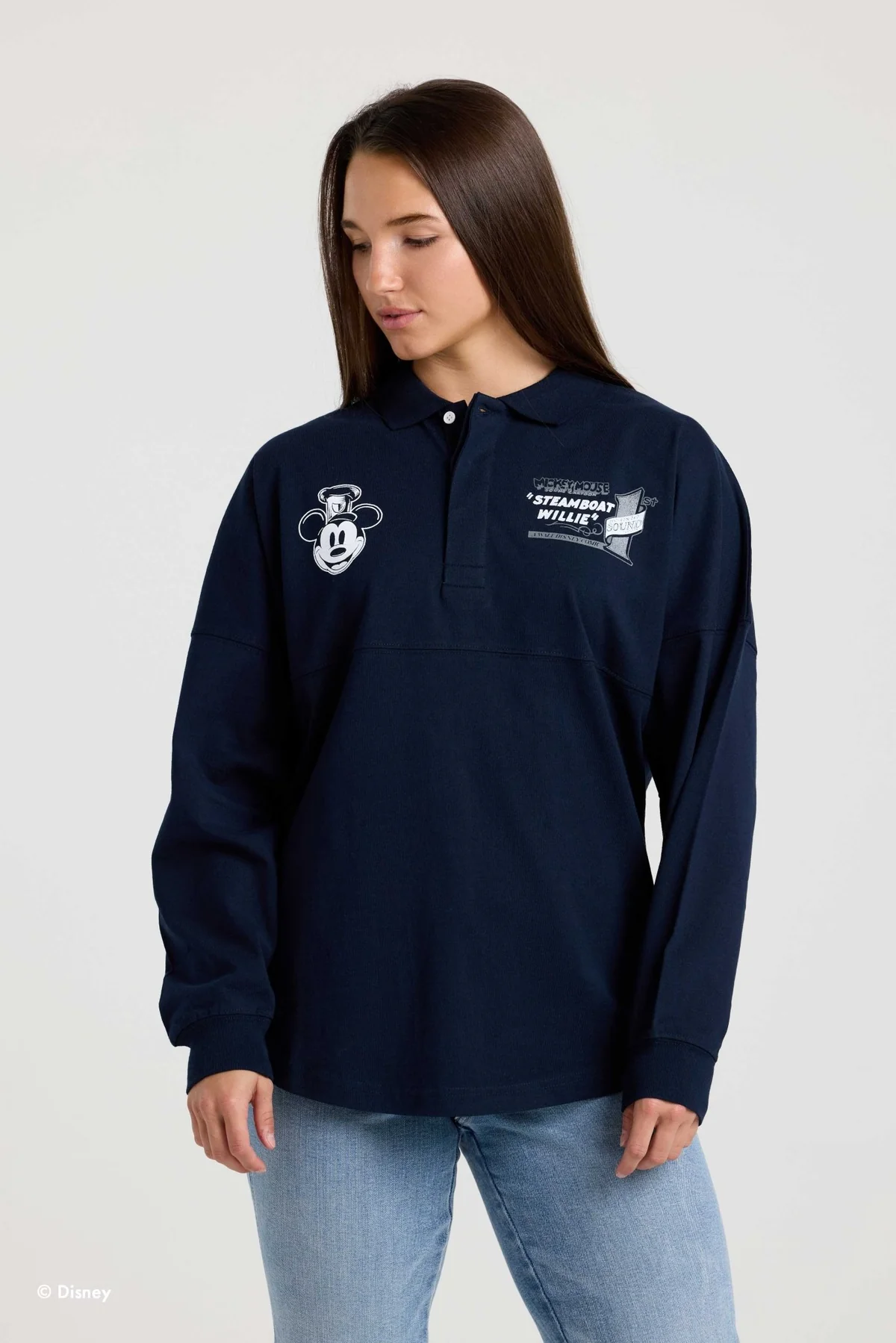 This navy blue, collared Spirit Jersey shows Steamboat Willie's face on the righthand chest and a title card image from the short on the lefthand chest.