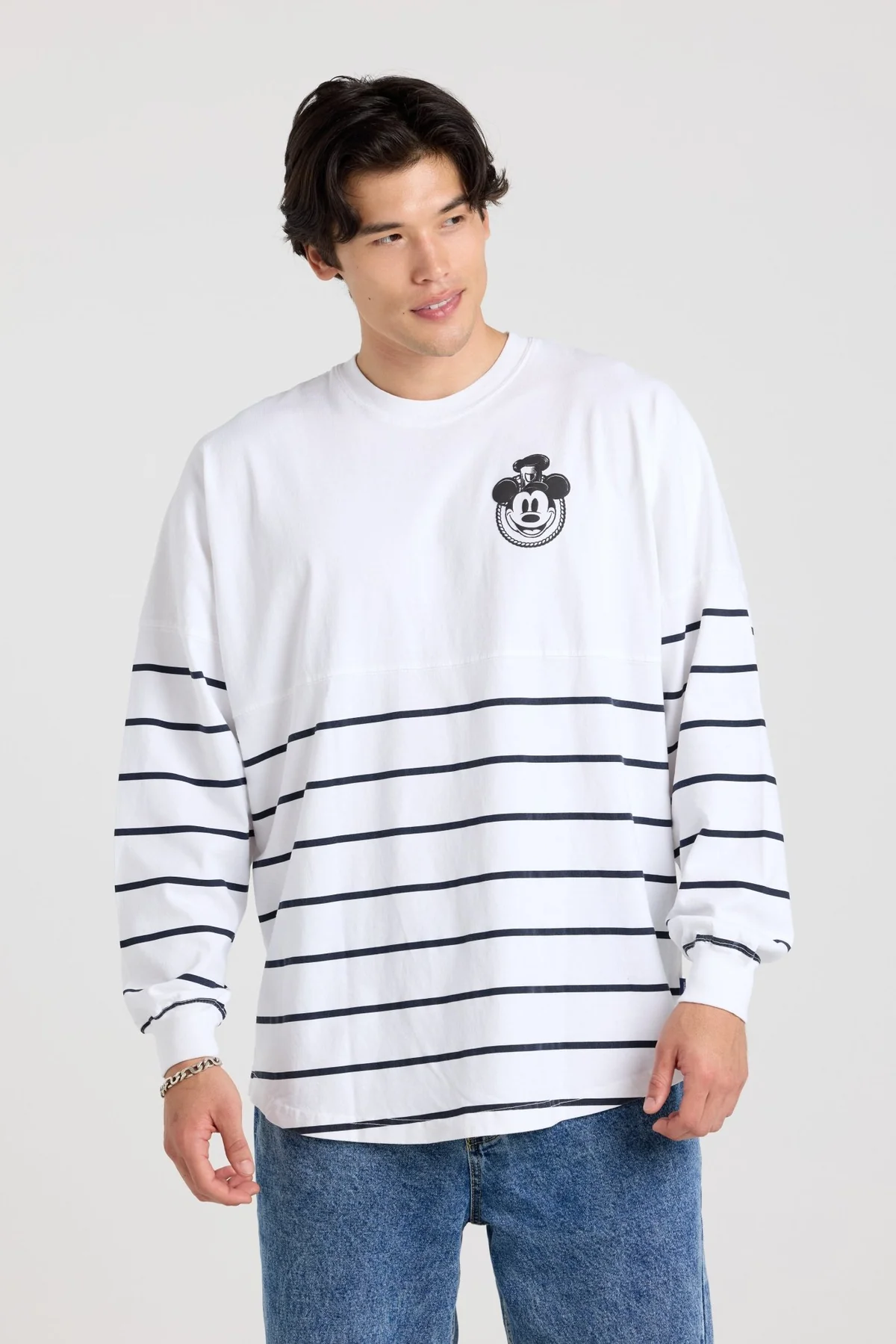 In white, with the bottom half covered in medium blue horizontal stripes, this is a traditional Spirit Jersey. It shows a black and white image of Steamboat Willie's face on the lefthand chest.