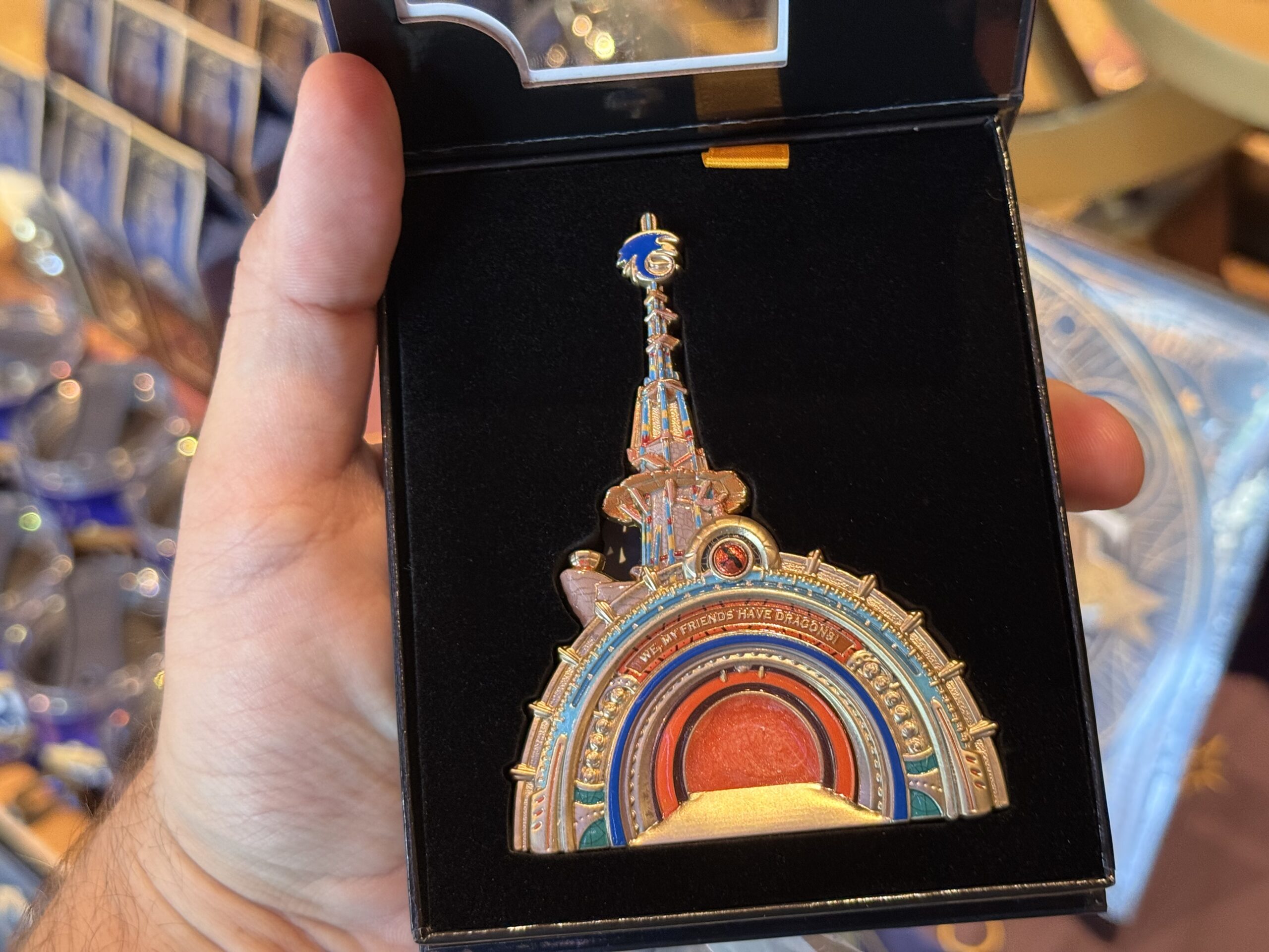 This portal pin is designed to look very similar to the real portal into Isle of Berk at Epic Universe. Featuring blues and oranges, it has "We, my friends have dragons!" It stands up. We found it in Other Worlds Mercantile in Celestial Park.