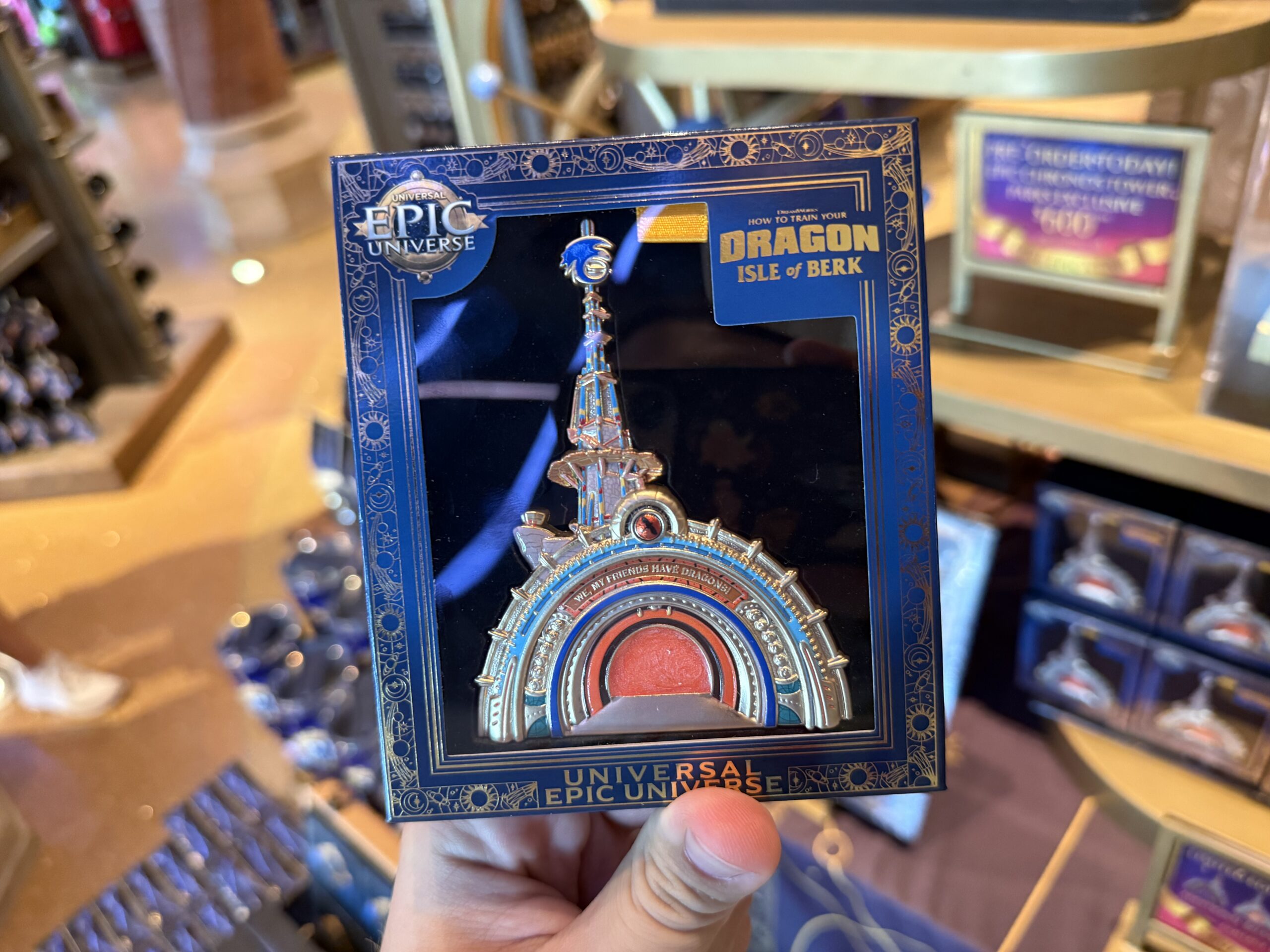 This portal pin is designed to look very similar to the real portal into Isle of Berk at Epic Universe. Featuring blues and oranges, it has "We, my friends have dragons!" It stands up. We found it in Other Worlds Mercantile in Celestial Park.
