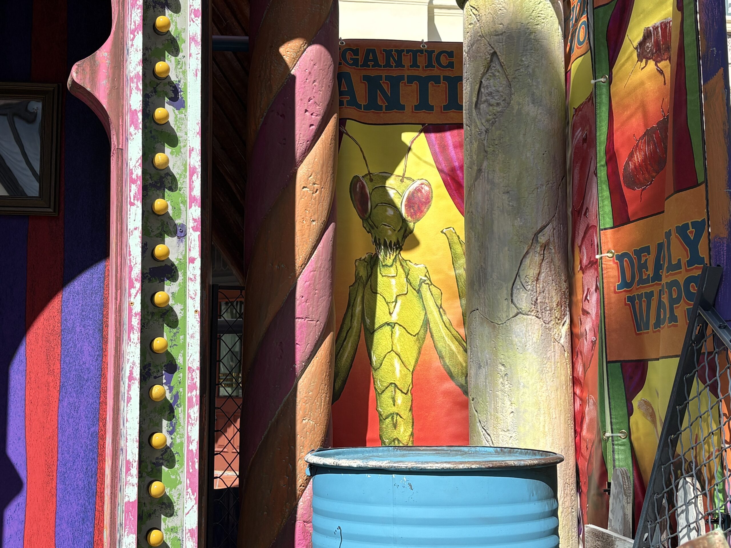 Made up of weathered but colorful walls, banners, and broken attractions, each set has a different theme. This one, as seen on the sign above the stage, is the "Unnatural," featuring strange creatures. Banners advertise a gigantic mantis, hissing roaches, deadly wasps, and a flesh eating plant.