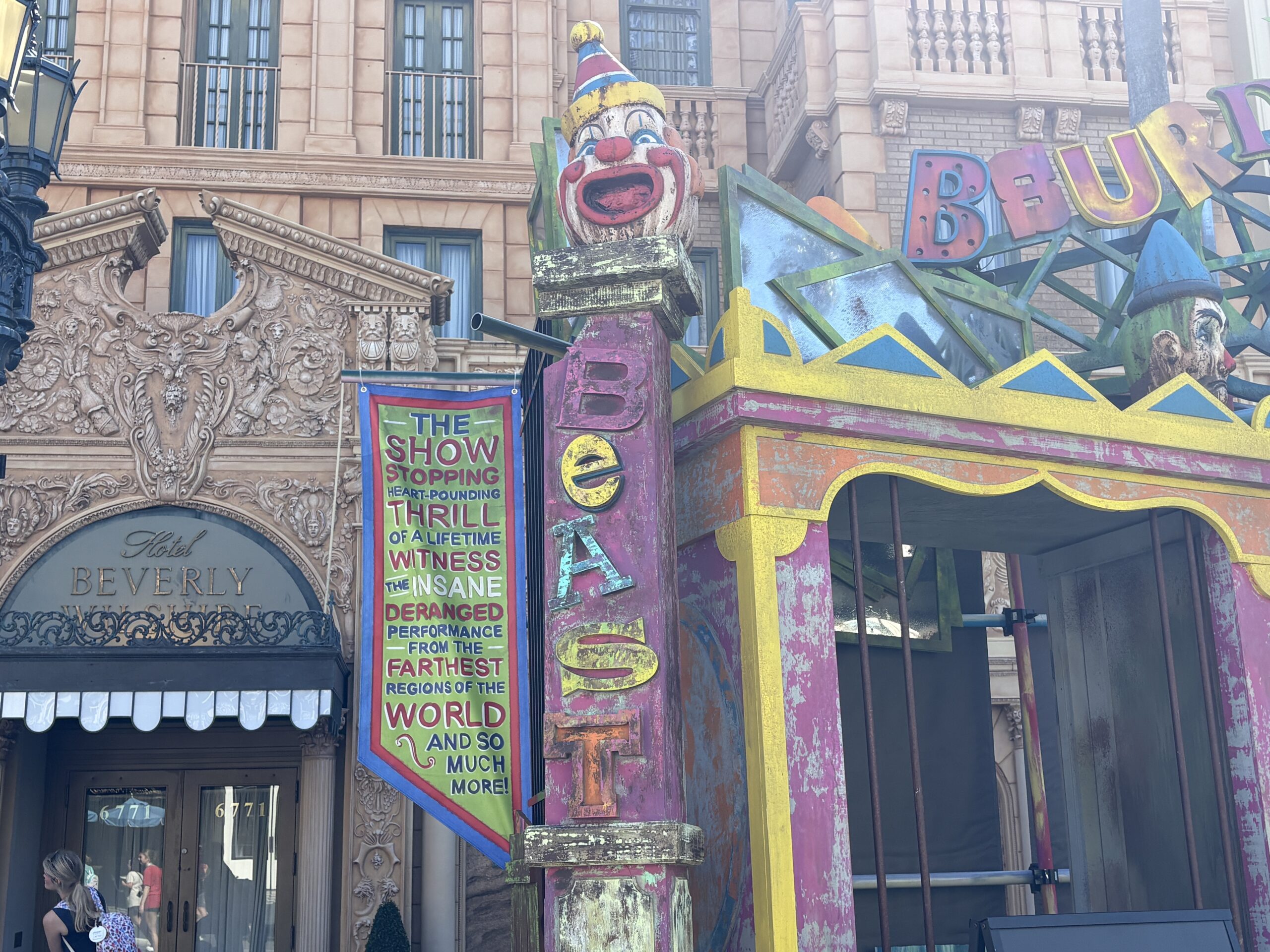 The other clown head is smiling atop a column with "Beast" spelled out on it. A hanging banner reads: