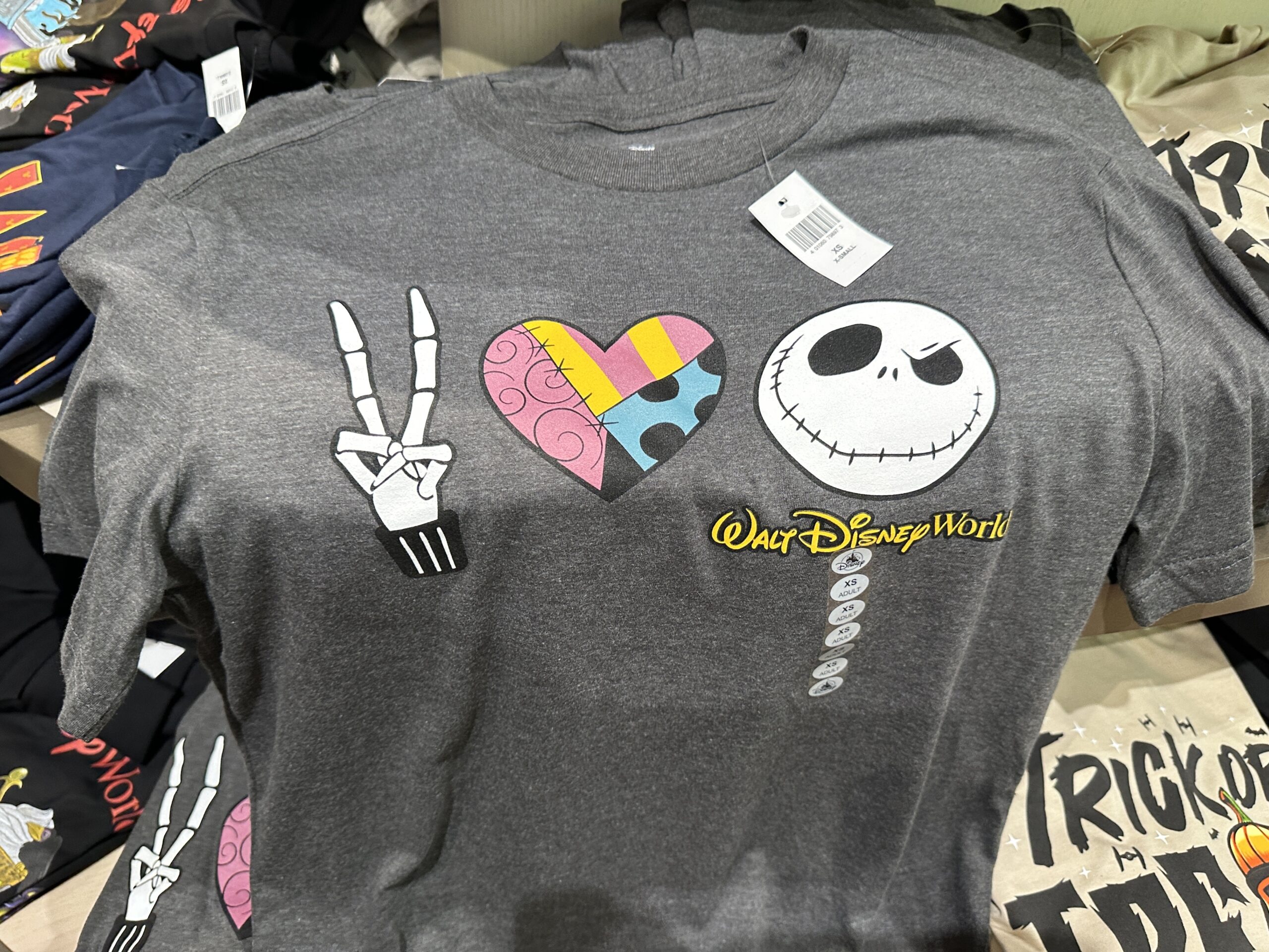 This gray shirt symbolizes peace, love, and Jack Skellington. Jack's fingers make the peace sign, the heart is filled with a Sally-inspired pattern, and Jack's face is on the end.