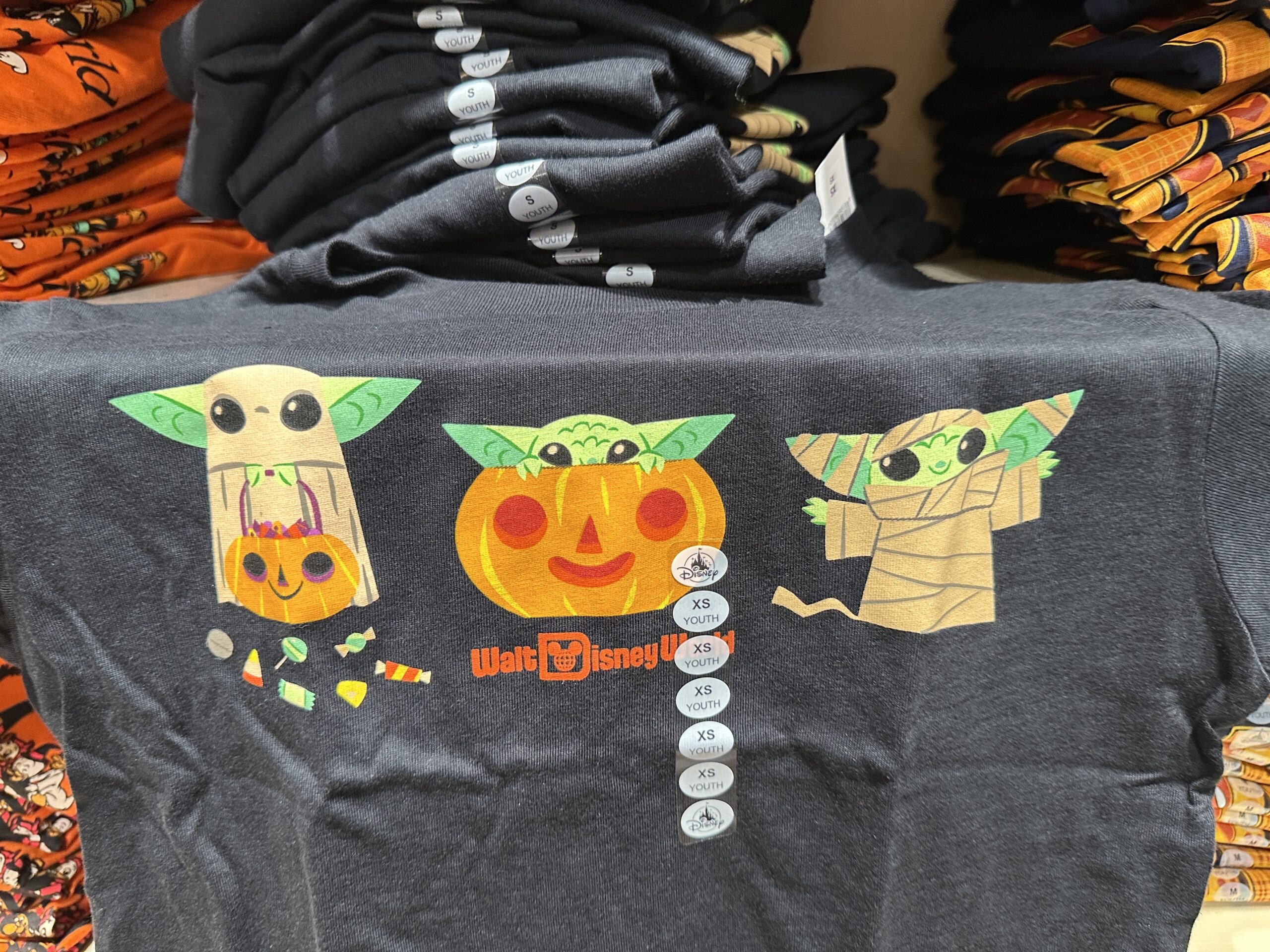 This black tee has three images of Grogu: trick-or-treating with candy, sitting inside a Jack-o’-lantern, and dressed as a mummy.