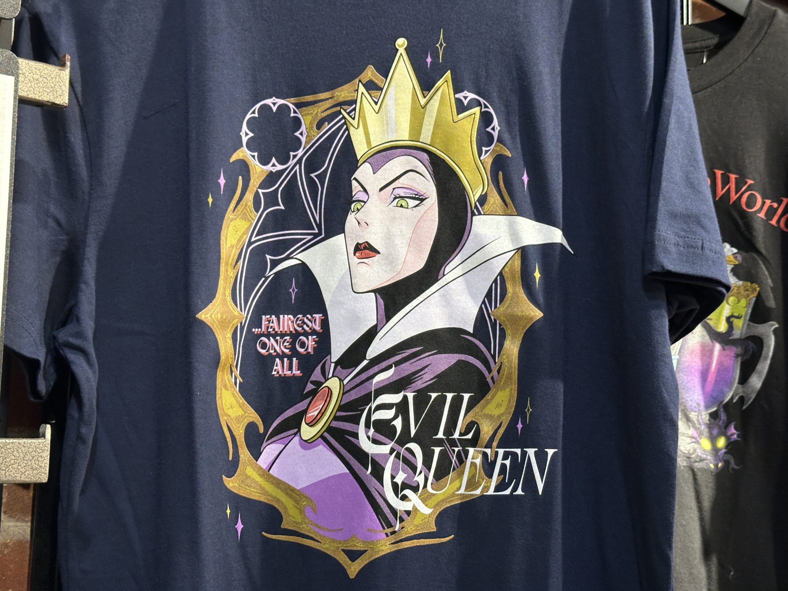 The navy tee has an image of the Evil Queen with "....Fairest One Of All" and "Evil Queen" text around her.