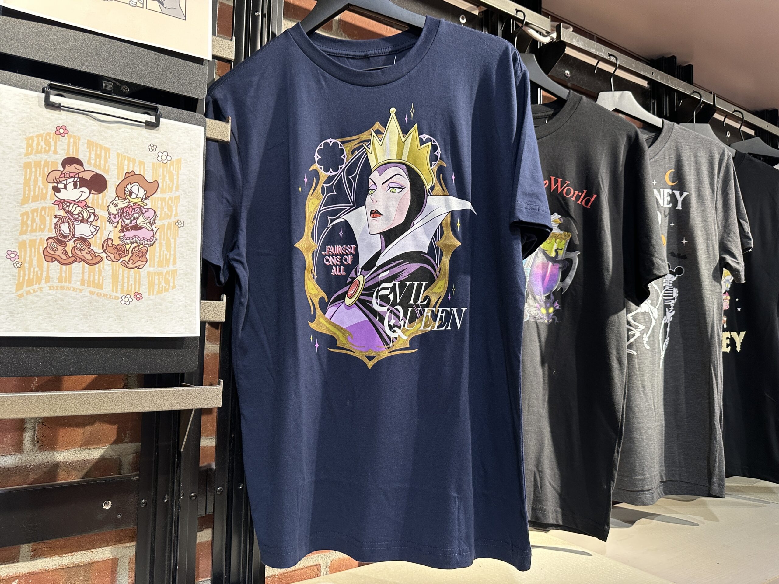 The navy tee has an image of the Evil Queen with "....Fairest One Of All" and "Evil Queen" text around her.