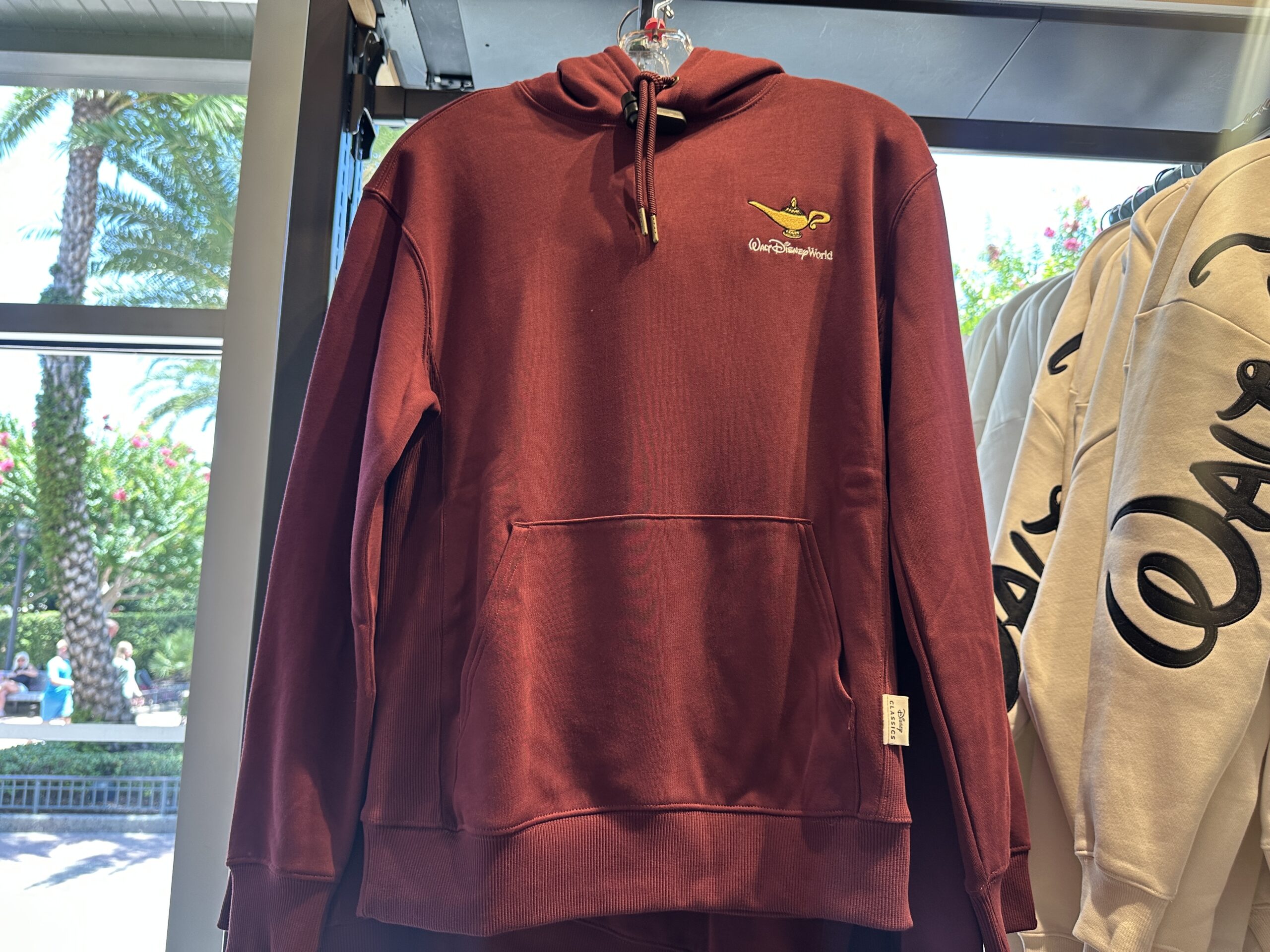 The hoodie is a similar shade of red as the tee. It has a drawstring hood and kangaroo front pocket.