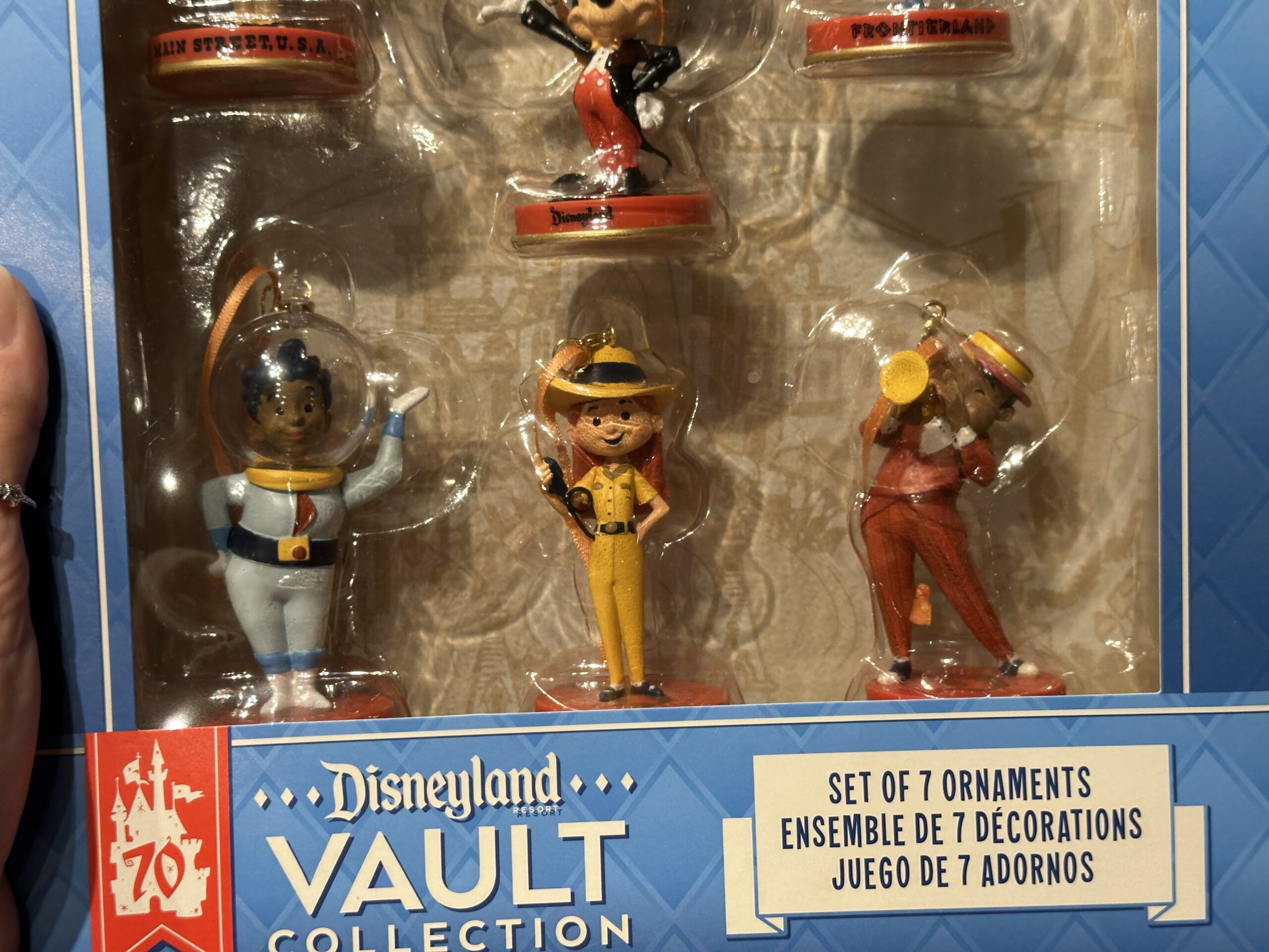 Representing Tomorrowland is an astronaut, while a Jungle Cruise skipper represents Adventureland, and a trumpeter represents New Orleans Square.