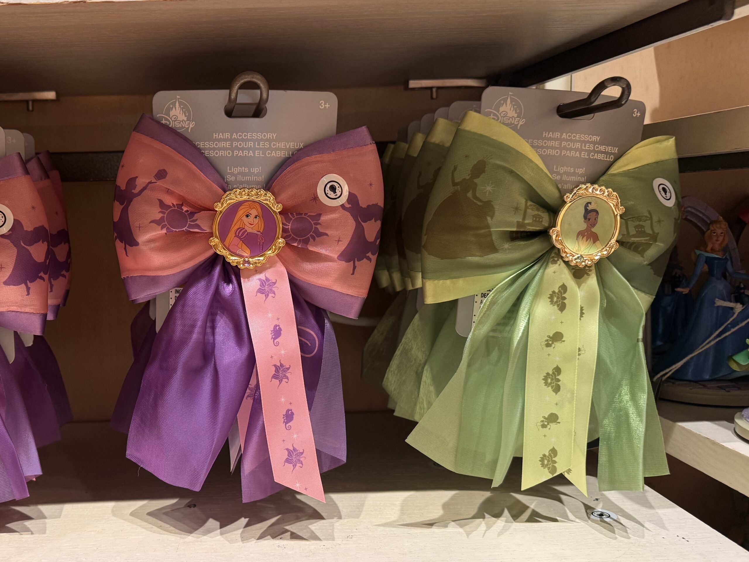 Disney World has released new hair bows featuring Rapunzel and Tiana. They come with a silver hair clip and light up.