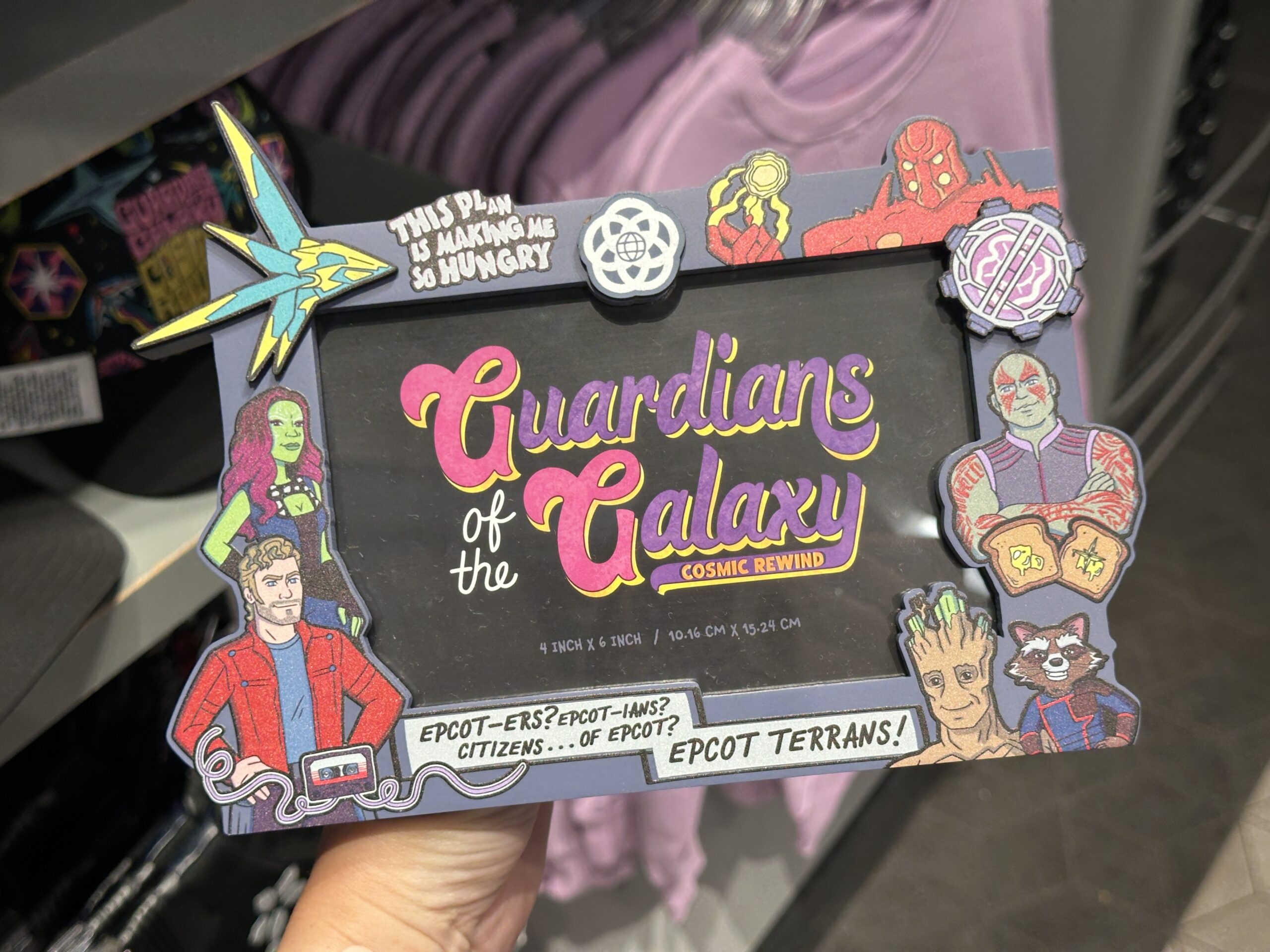 The Guardians are pictured on the sides of this blue frame. Comic-style text across the bottom reads, "EPCOT-ers? EPCOT-ians? Citizens...of EPCOT? EPCOT Terrans!"