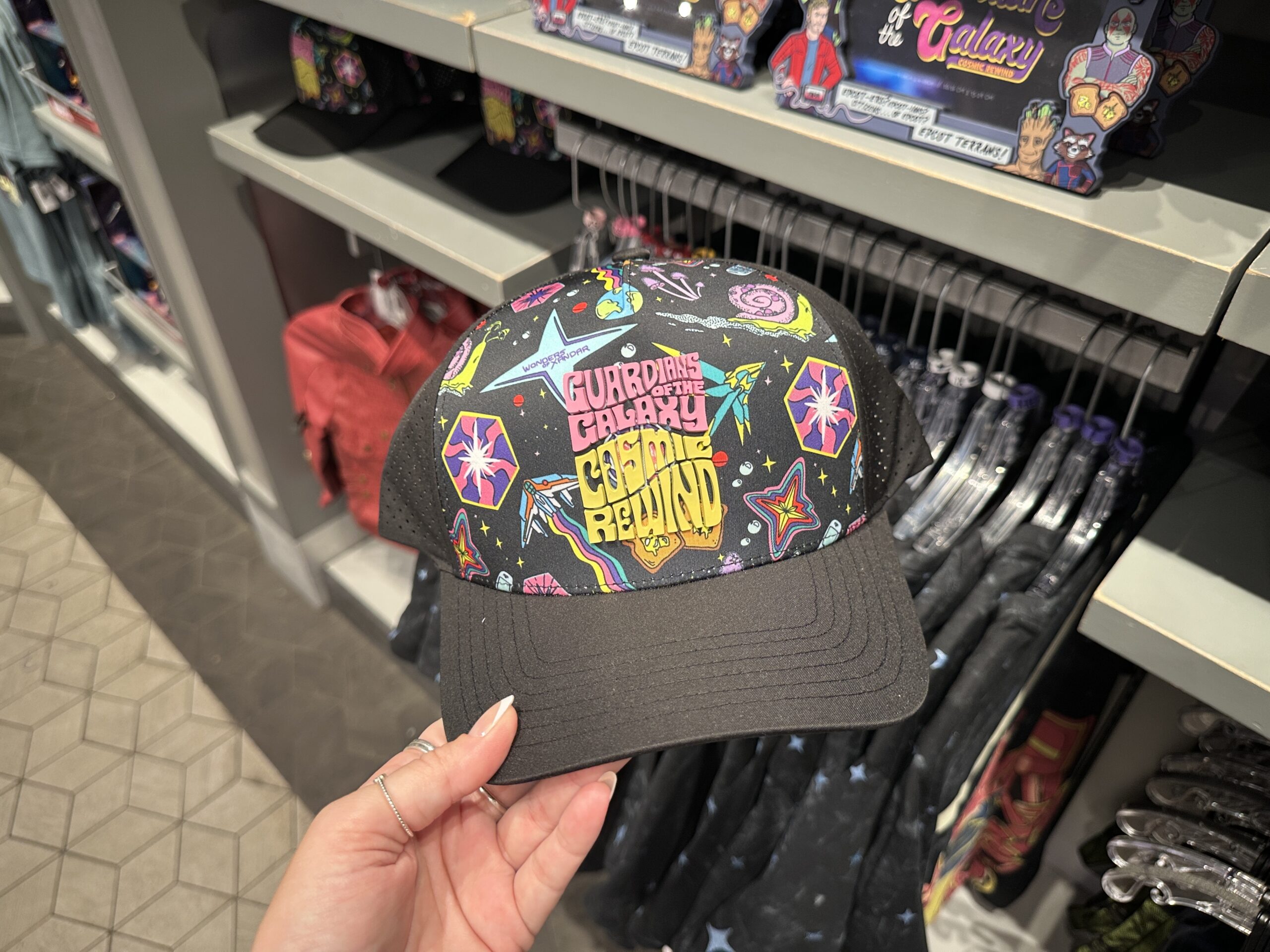 Retro-style icons of the ride are across the front panel of this black cap, behind "Guardians of the Galaxy: Cosmic Rewind" in groovy pink and yellow lettering. The art includes a Nova Corps ship, Xandarian snail, and jump points.