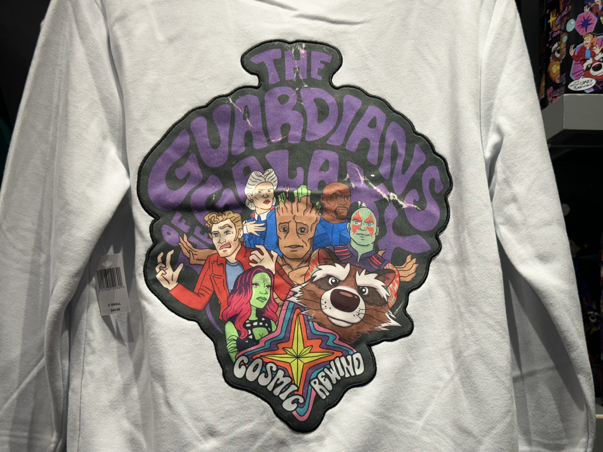 On the back is colorful artwork reminiscent of classic Scooby Doo cartoons. The Guardians are pictured, along with Nova Prime Irani Rael and Centurion Tal Marik. "The Guardians of the Galaxy" is in purple bubble lettering while "Cosmic Rewind" is in white around a rainbow Nova Corps logo.