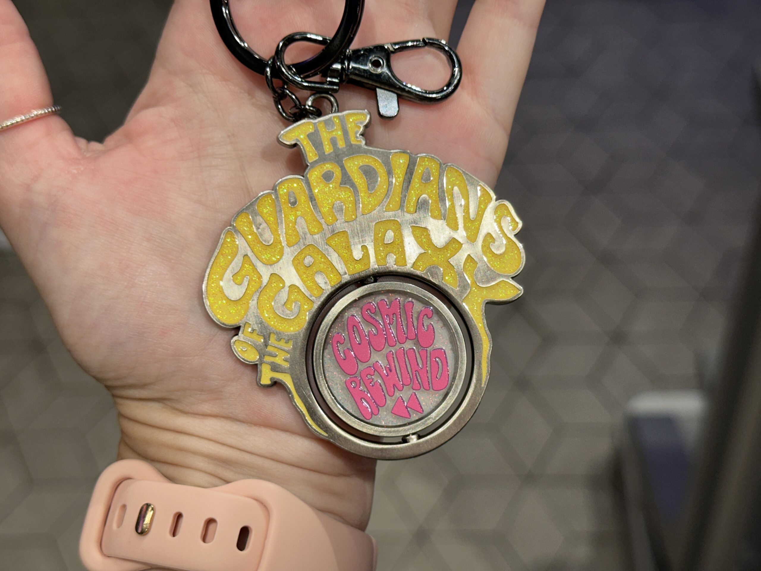 "The Guardians of the Galaxy" is in sparkly yellow lettering on this keychain. The spinning medallion reads "Cosmic Rewind" in pink on one side. On the reverse is art of the ride's characters.