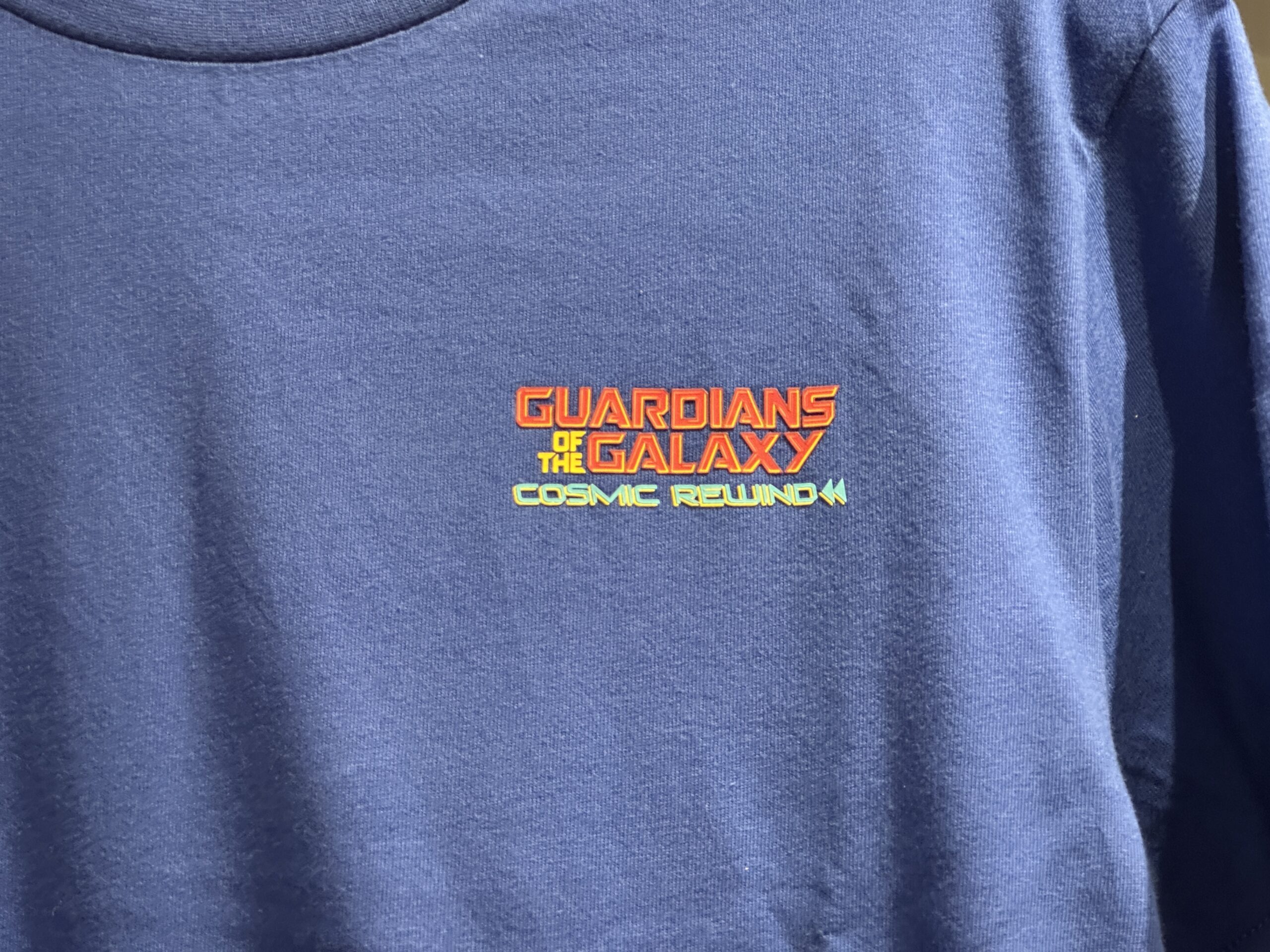 The Guardians of the Galaxy: Cosmic Rewind wordmark is on the left chest of this blue tee.