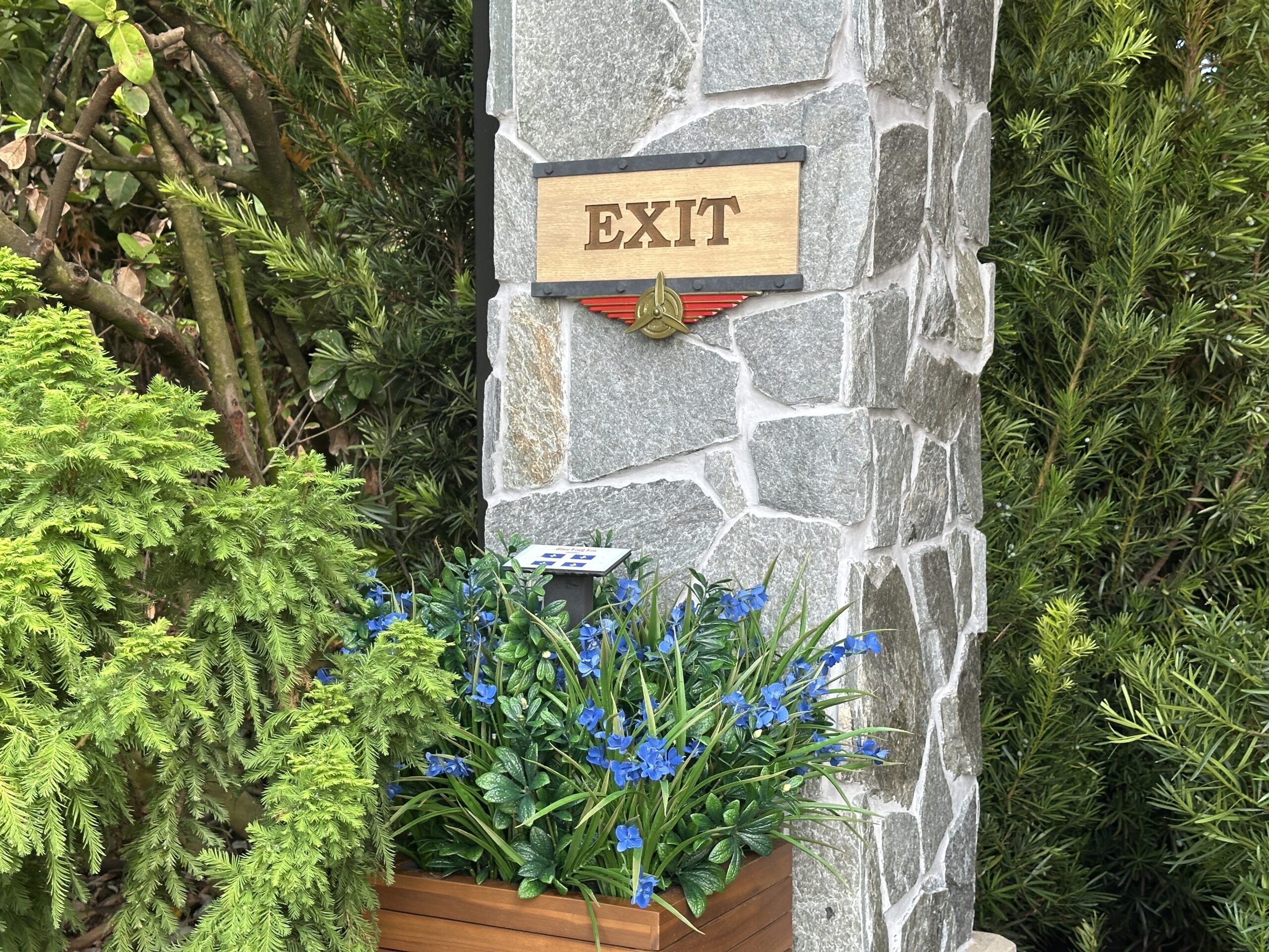 Airplane-inspired iconography includes golden propeller plaques under the "Exit" and "Enter" signs of the queue.