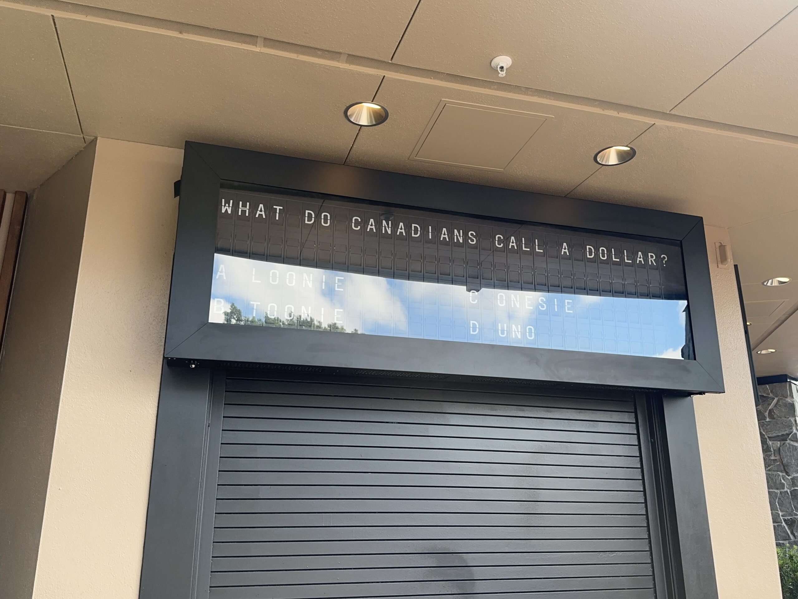 Above the pick-up window is a retro airport message board featuring Canada trivia. For example, what do Canadians call a dollar?