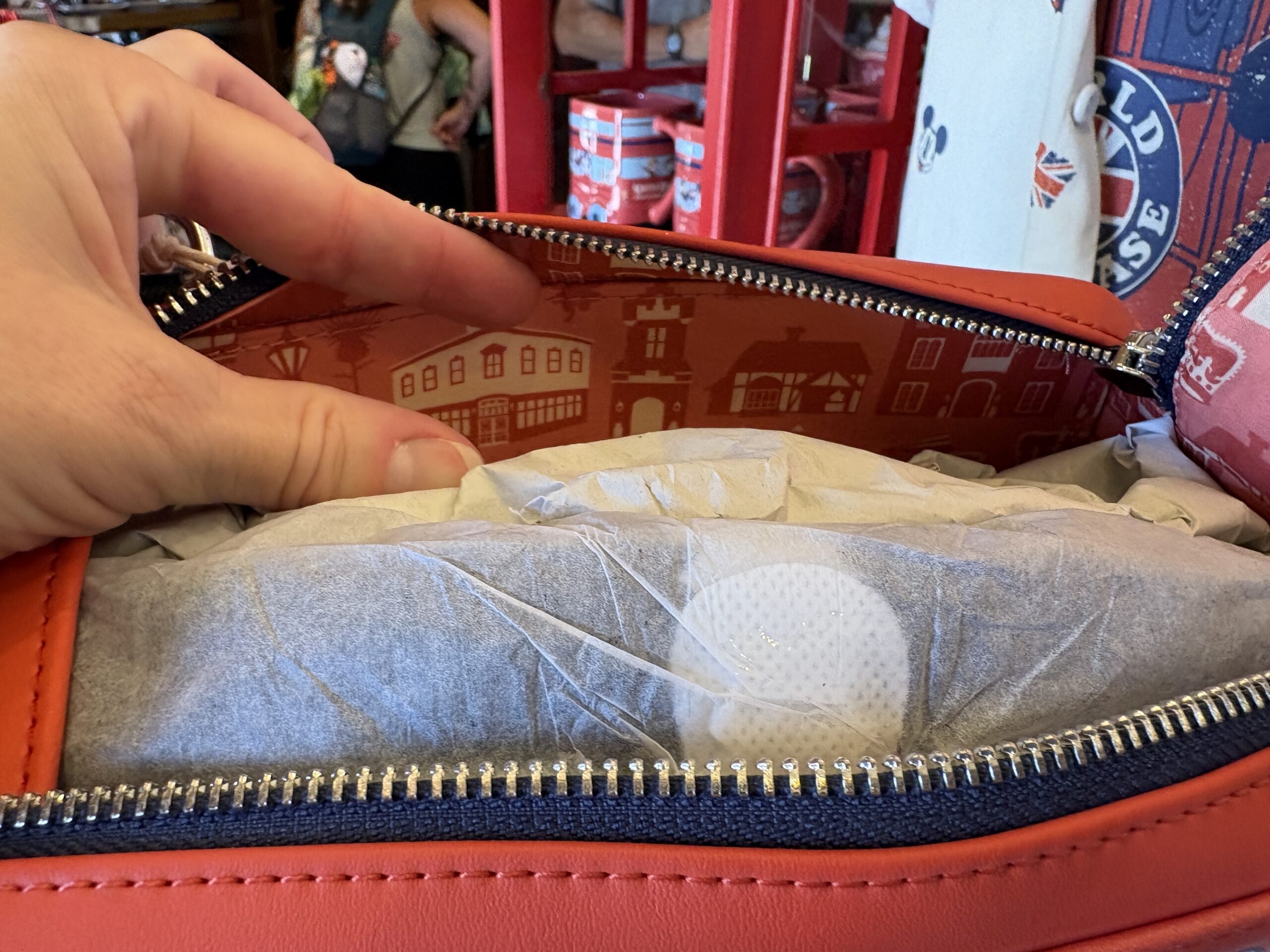 The interior lining is pink with an all-over print of red U.K. buses, telephone booths, and buildings.