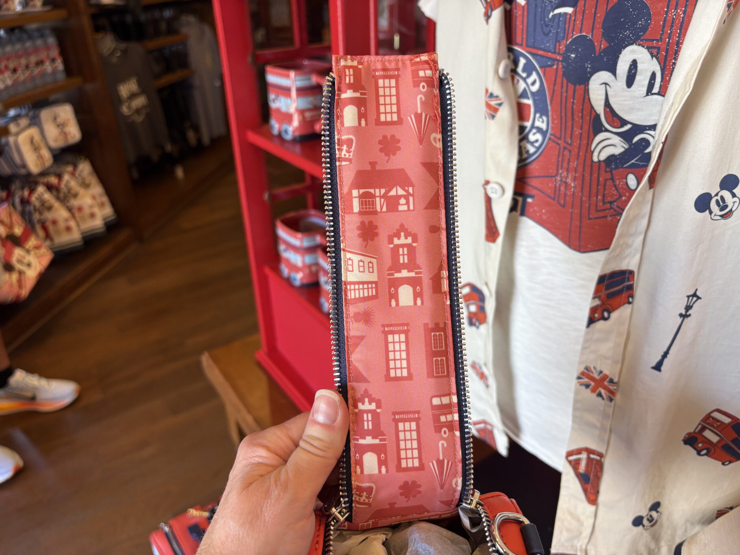 The interior lining is pink with an all-over print of red U.K. buses, telephone booths, and buildings.