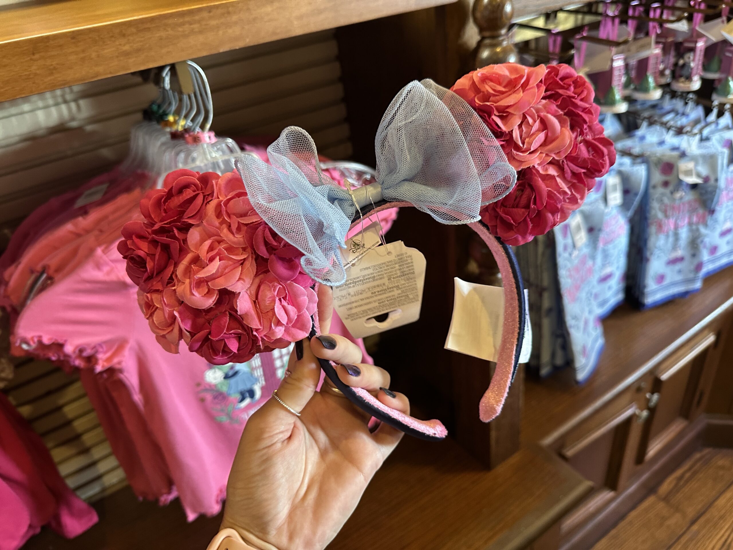 These ears are covered in faux roses in two different pink shades. It has a blue tulle double-layered bow.