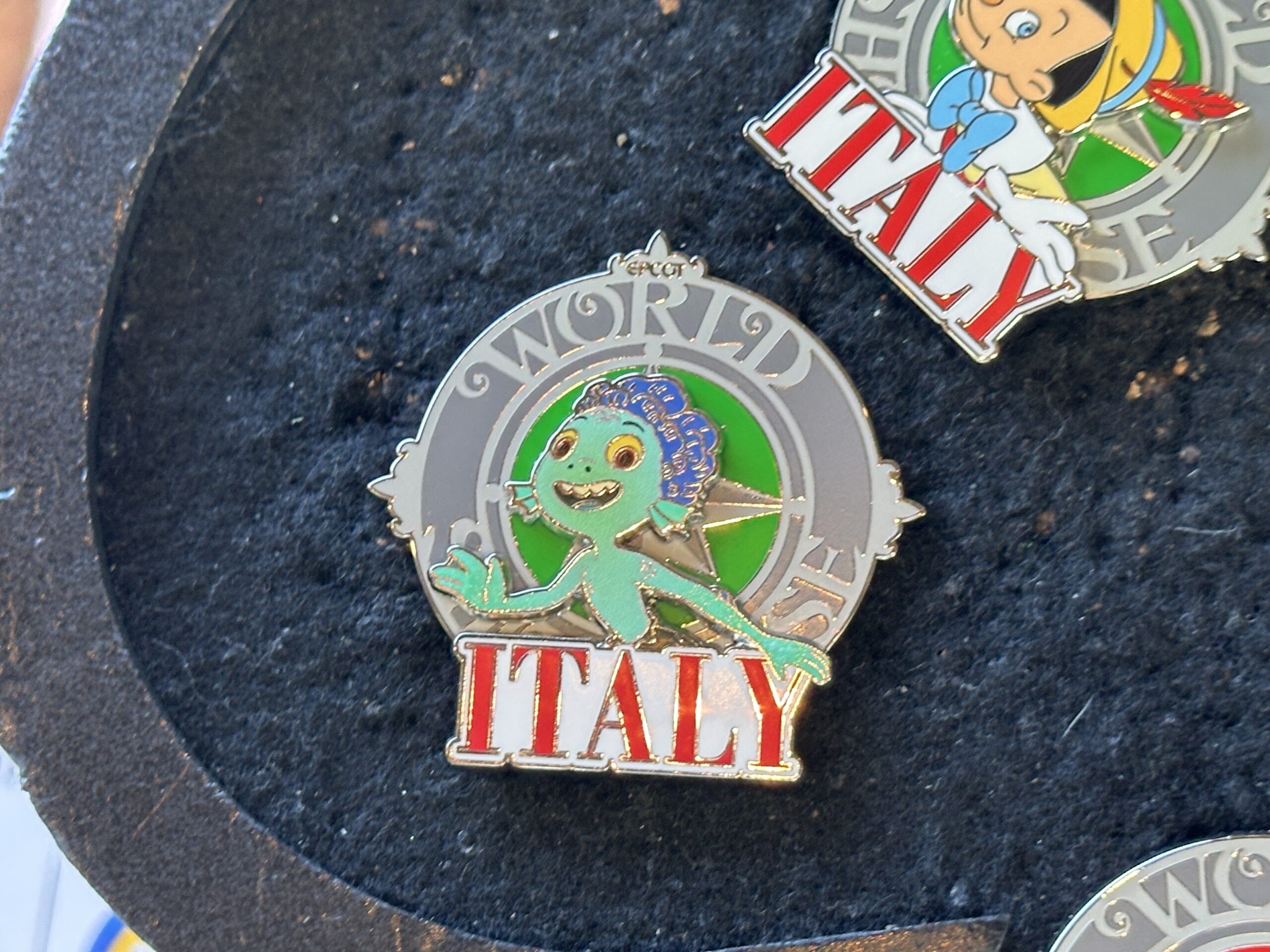 Luca is pictured in his sea monster form with a green background and "Italy" in red lettering.
