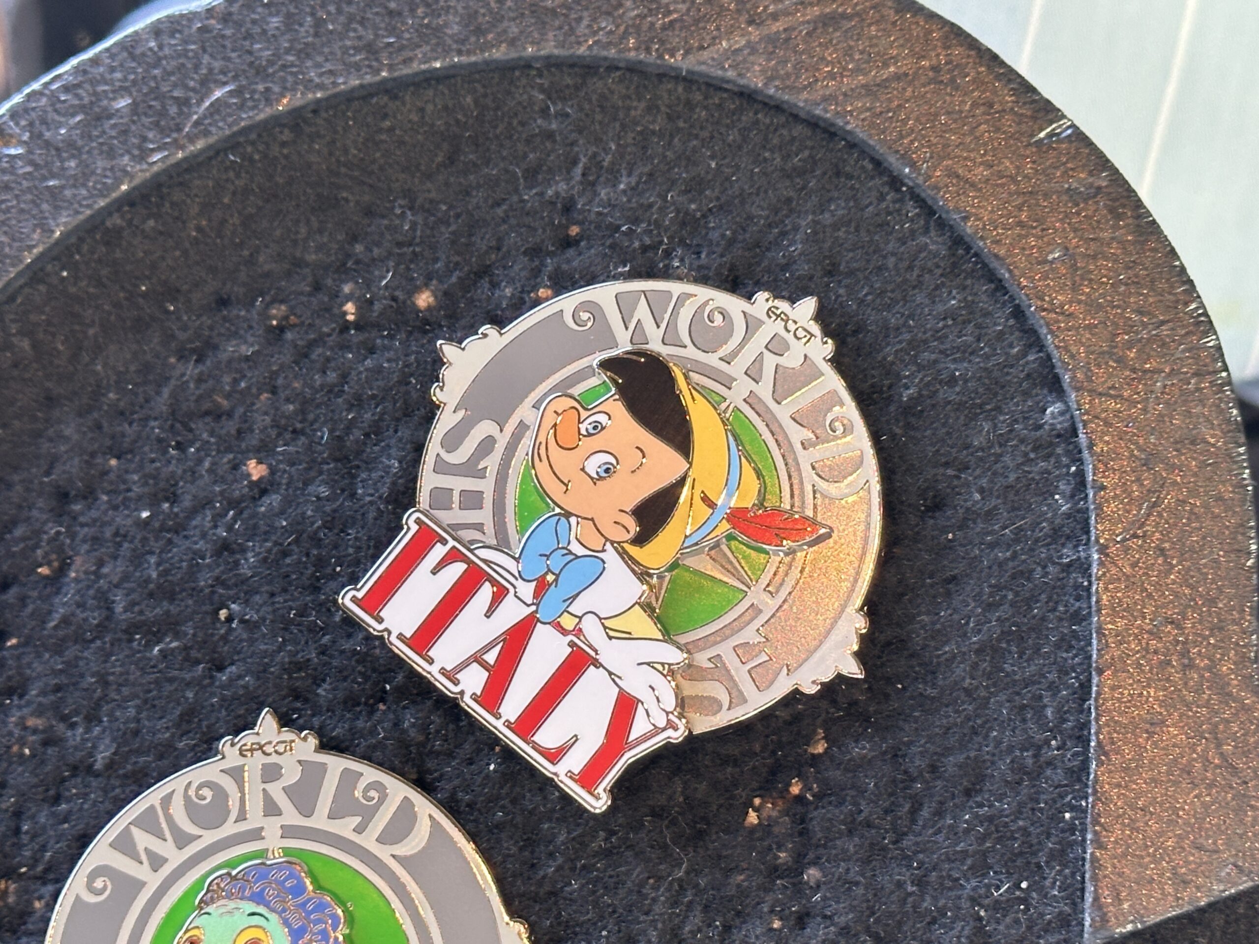 This pin features Pinocchio, also against a green background.