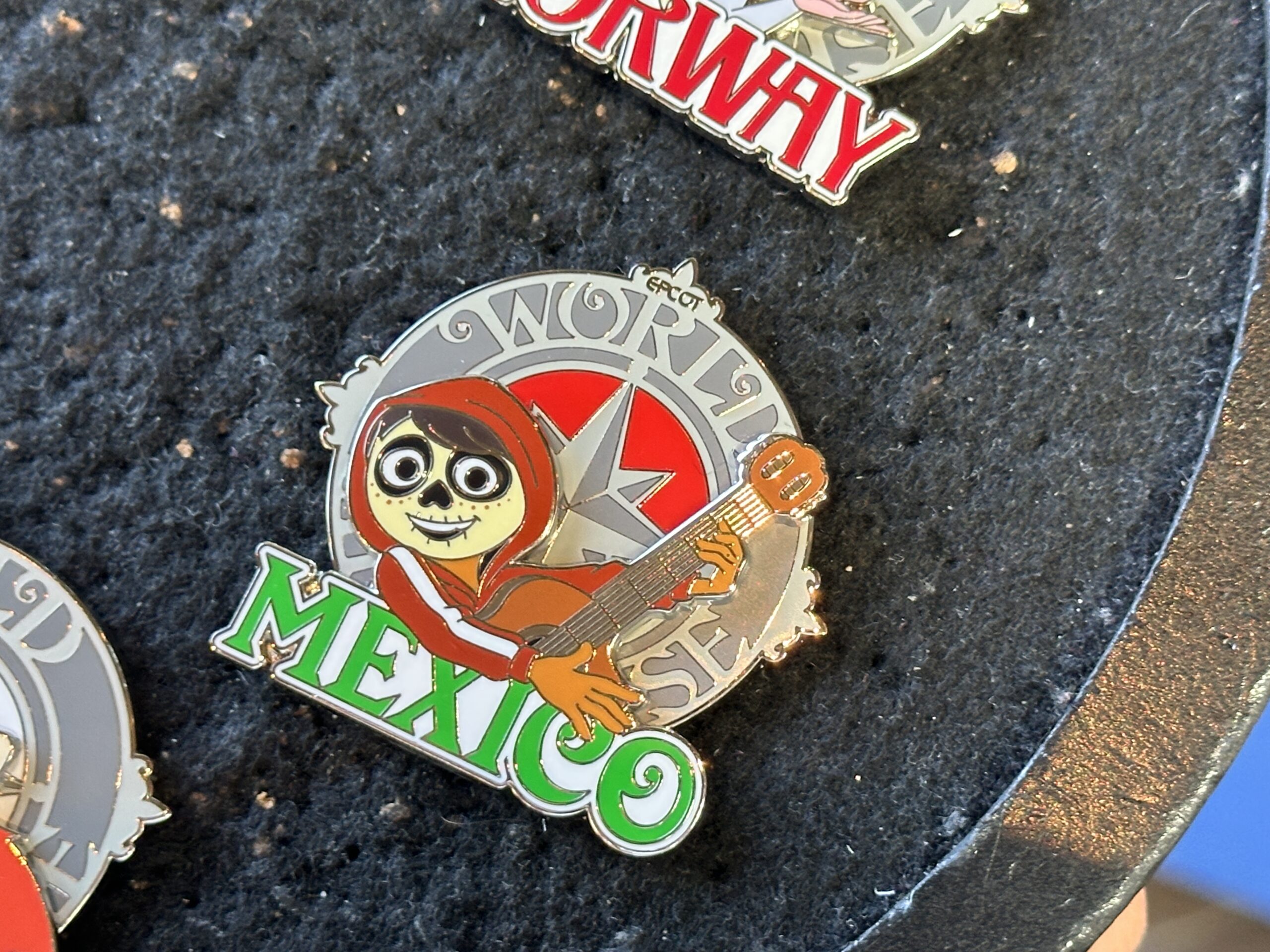 Miguel from Coco plays guitar and has his skeletal face paint on the Mexico pin.