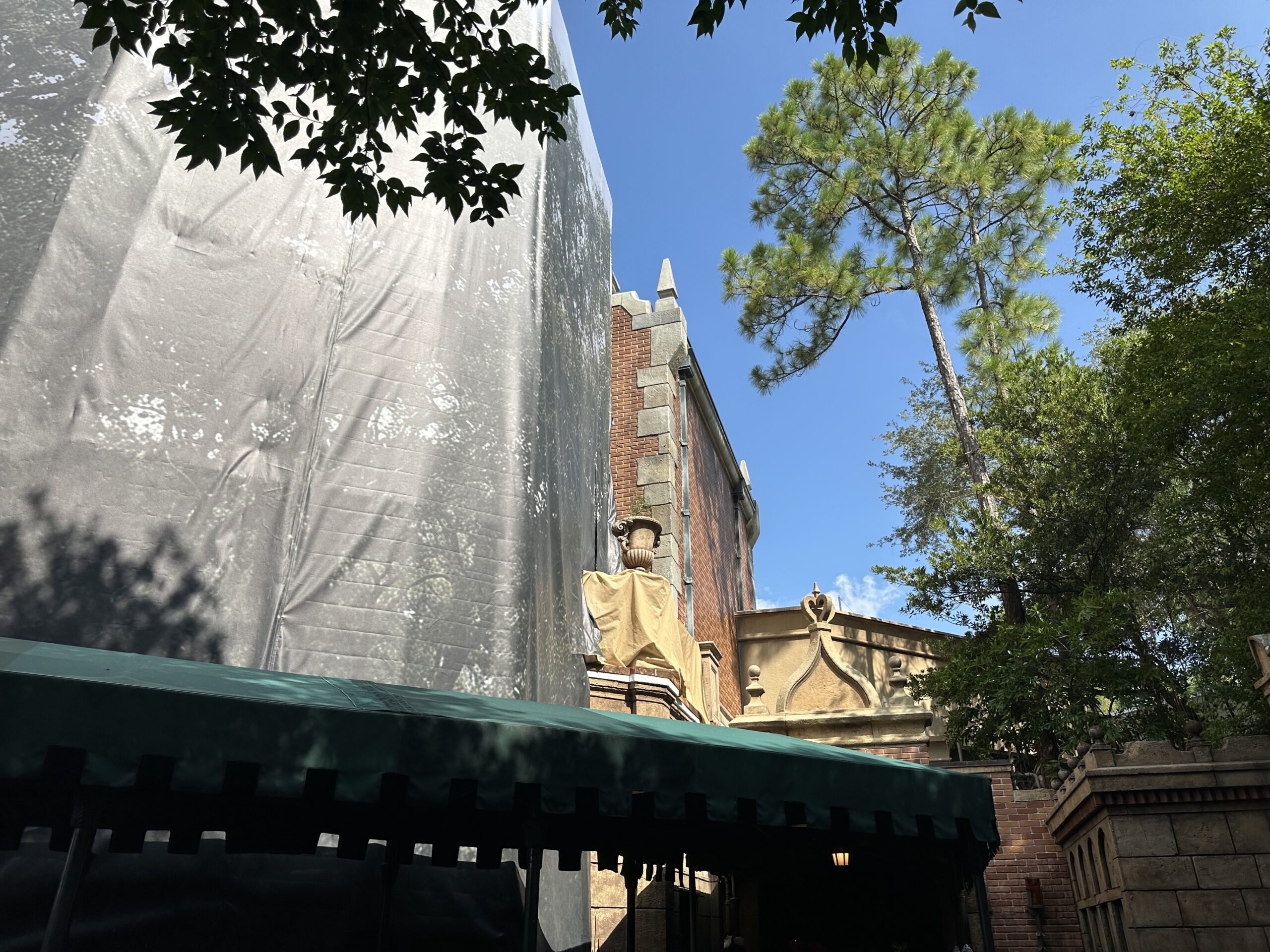 Scrims and scaffolding went up around the chimneys in March. Though scaffolding came down from one pair of chimneys in June, it went back up soon after. The scaffolding is now gone again, and it looks like the chimneys have darker detail paint, making them look more realistically burnt and soot-covered.