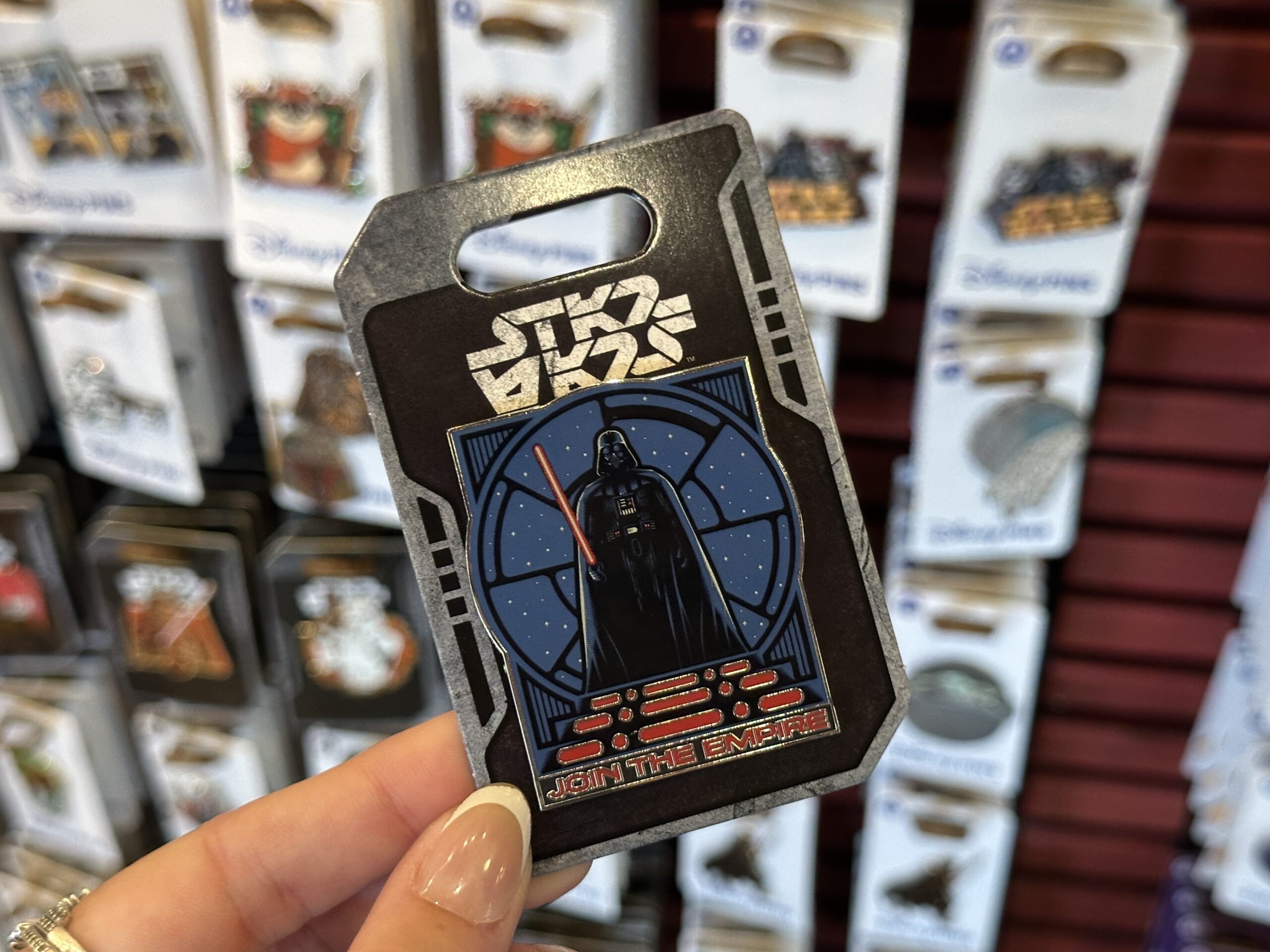 Also in Frontier Trading Post is this Darth Vader pin featuring the Star Wars villain against a circular window looking out at a starry sky. "Join the Empire!" is in red at the bottom.