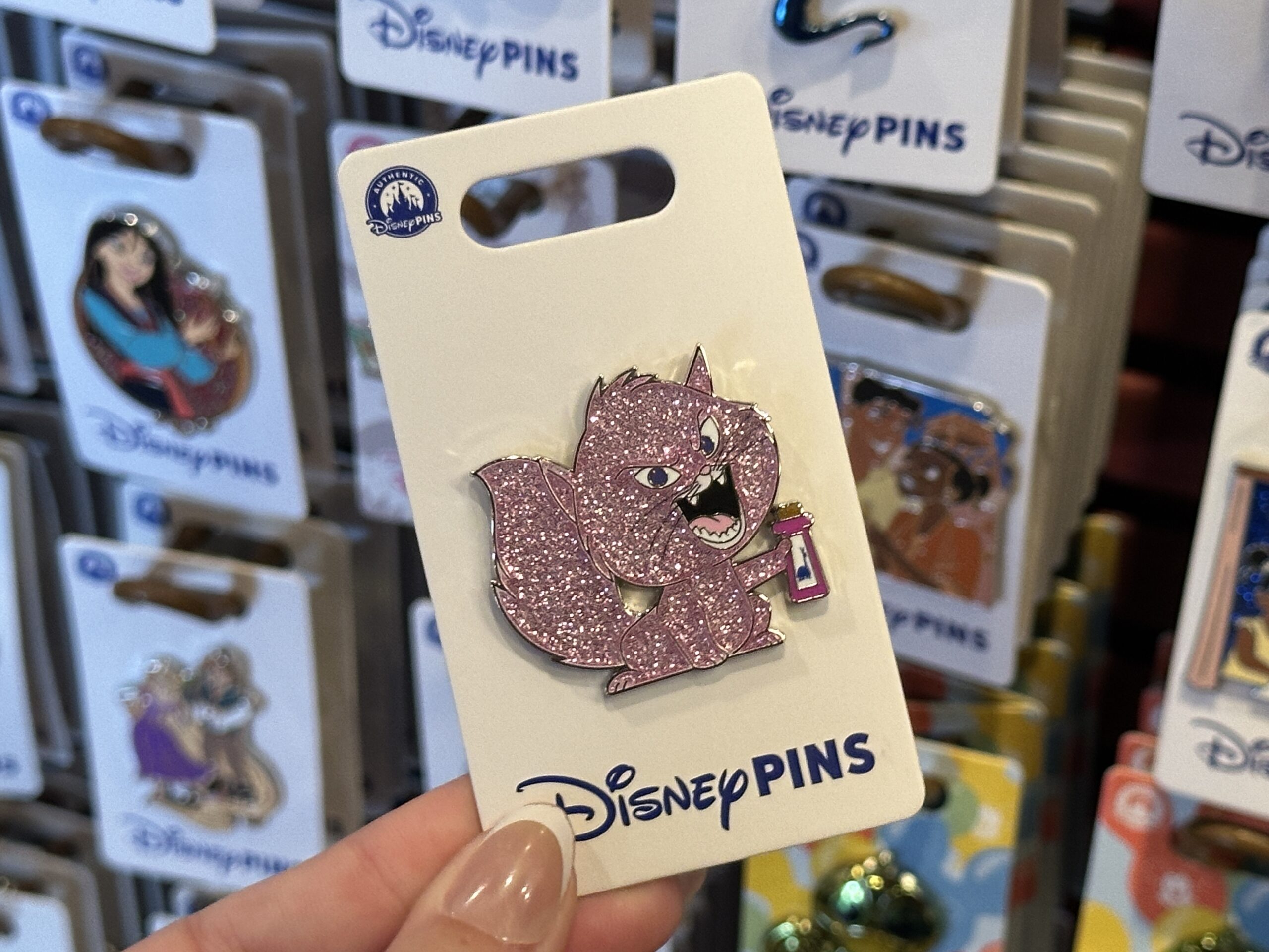 This Yzma pin is a similar glittery style. It depicts her as a cat holding the llama potion.