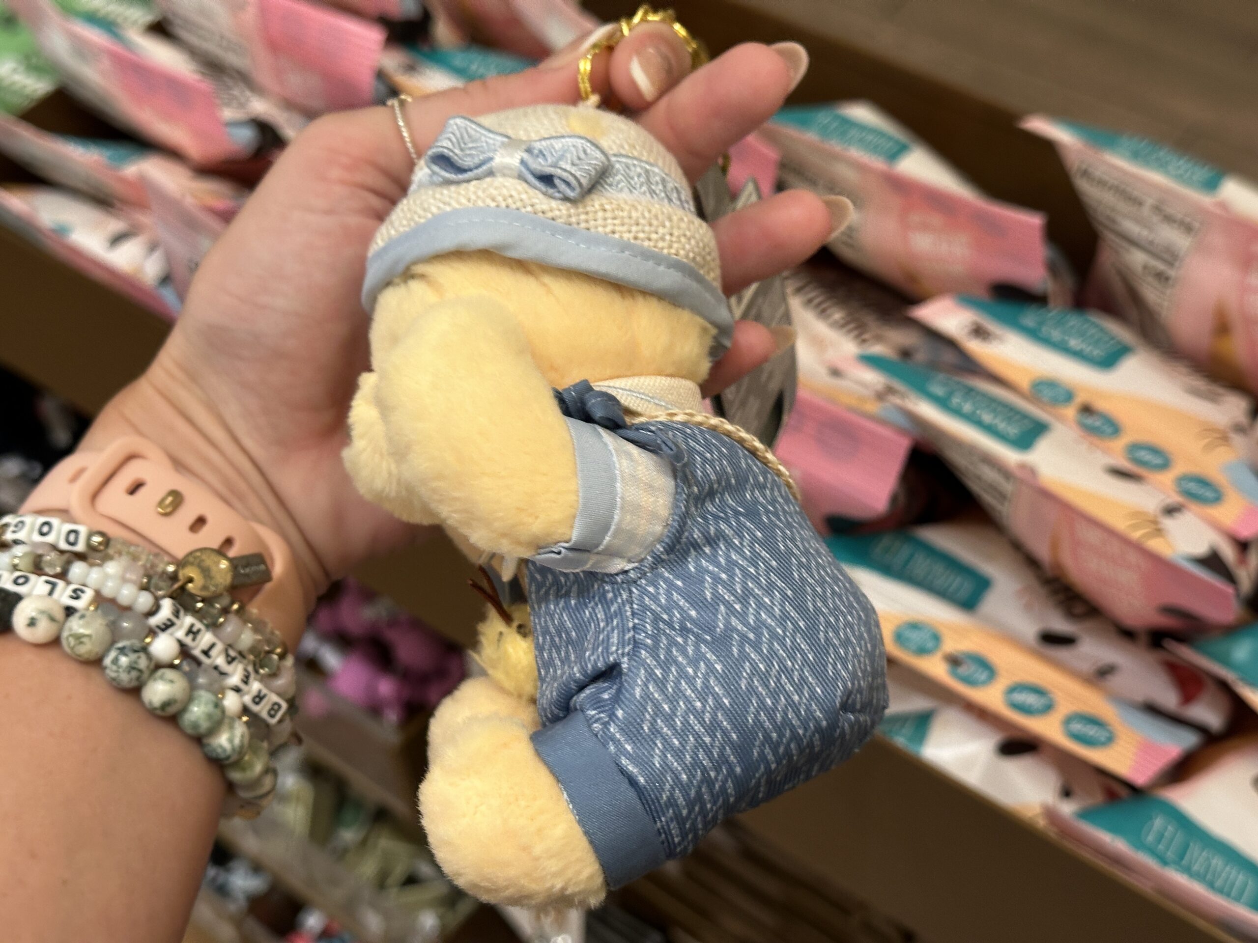 On his bucket hat are a blue bow and green felt clover. His arms are posable. All the keychains hang on a gold-tone chain with a split ring and lobster claw clip.