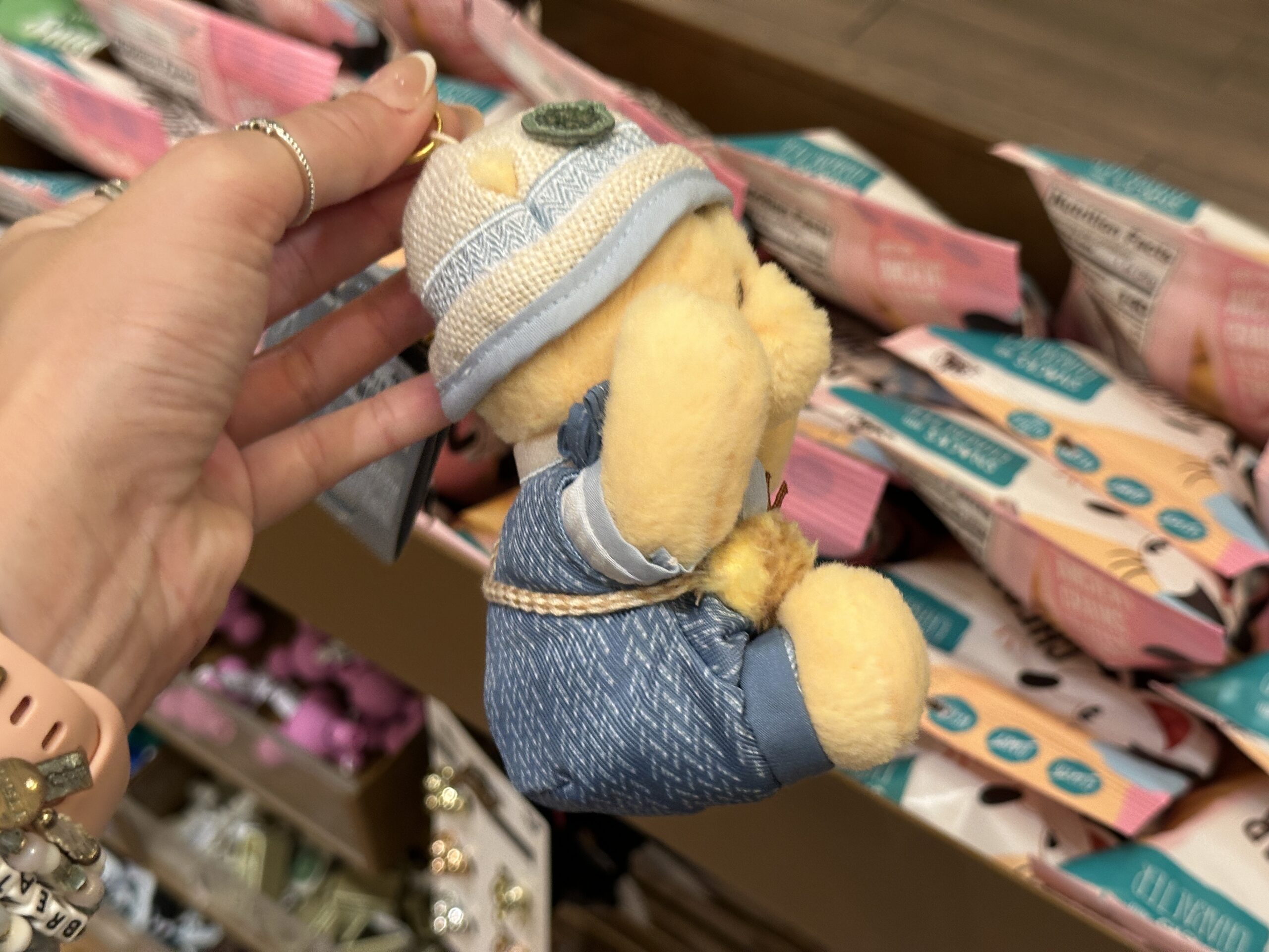 On his bucket hat are a blue bow and green felt clover. His arms are posable. All the keychains hang on a gold-tone chain with a split ring and lobster claw clip.