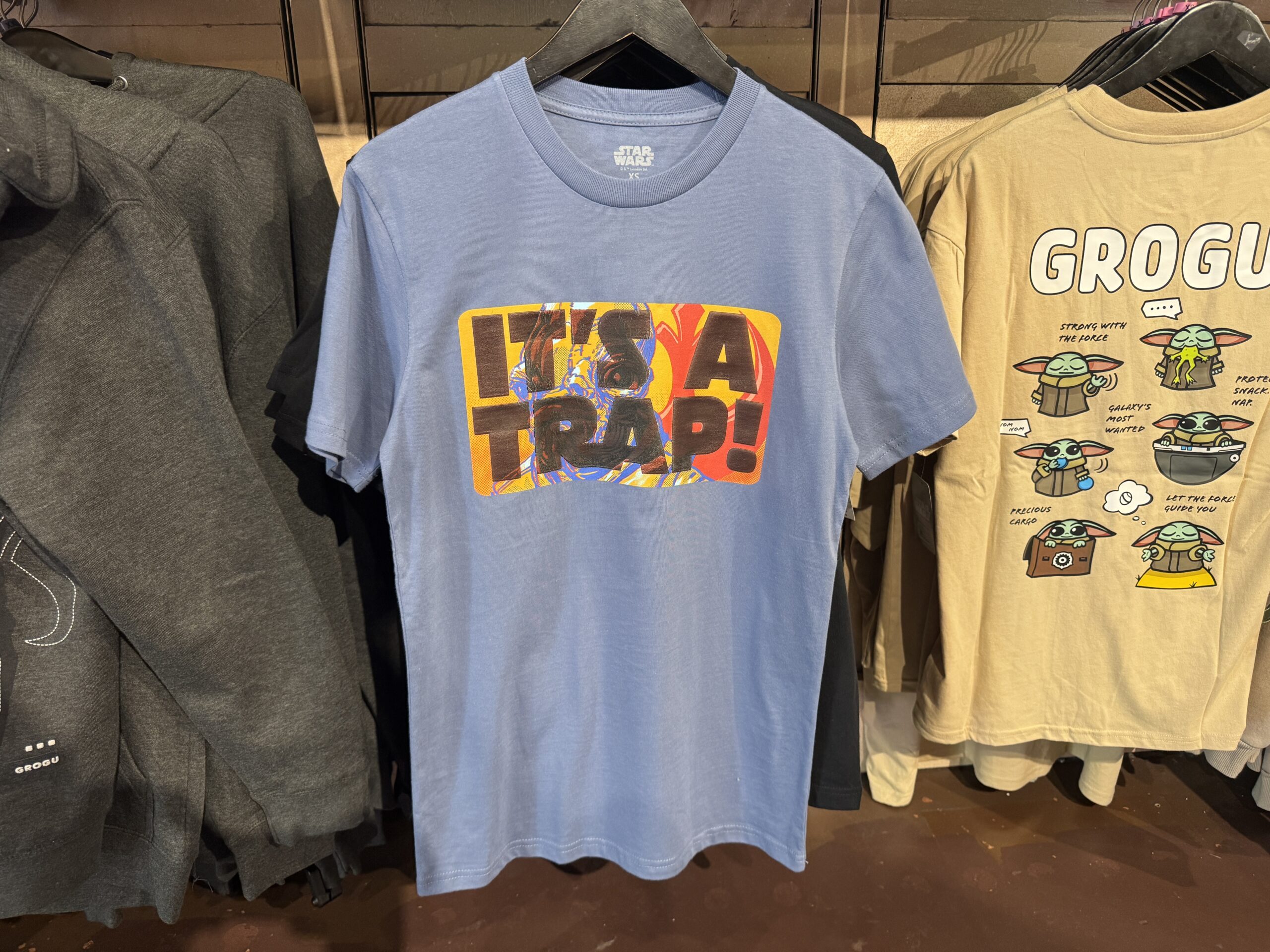 Inspired by Admiral Ackbar's famous line, this blue tee features "It's a trap!" in big letters against art of Ackbar and the Rebel Alliance logo.