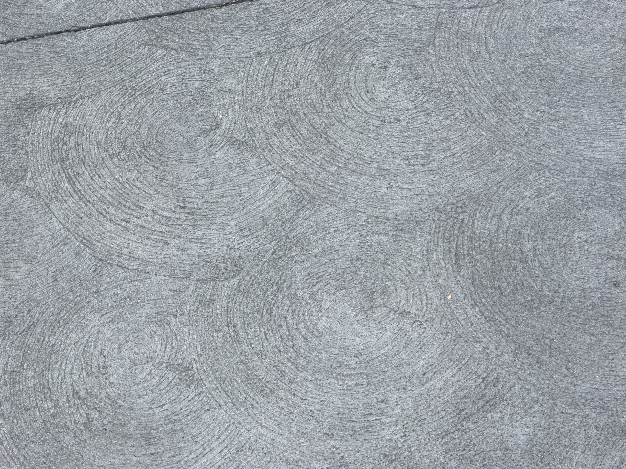 The new pavement has a subtle swirl pattern. It does look better than the splotchy pavement of late 2025.